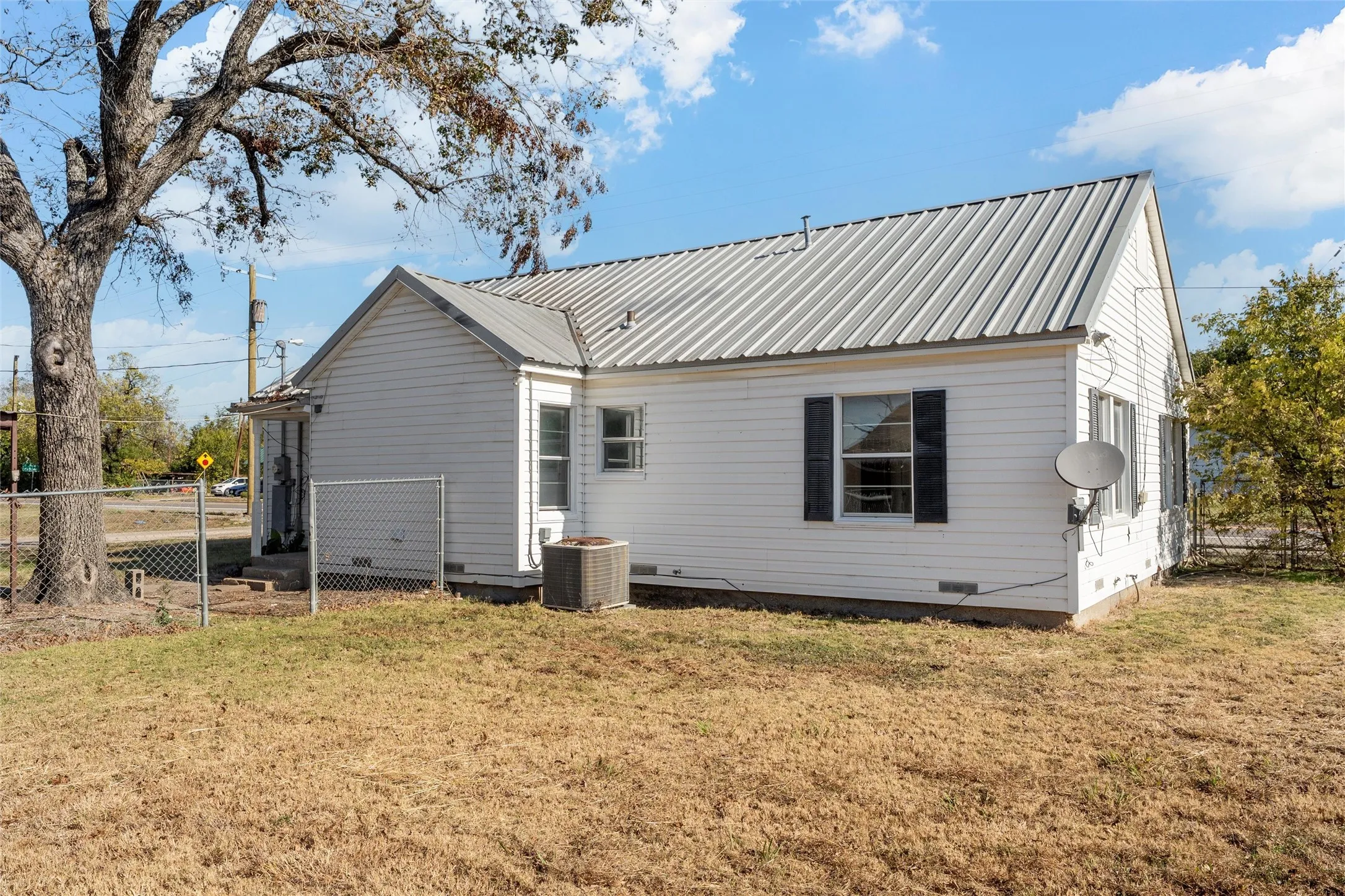 White siding exterior featuring a metal roof