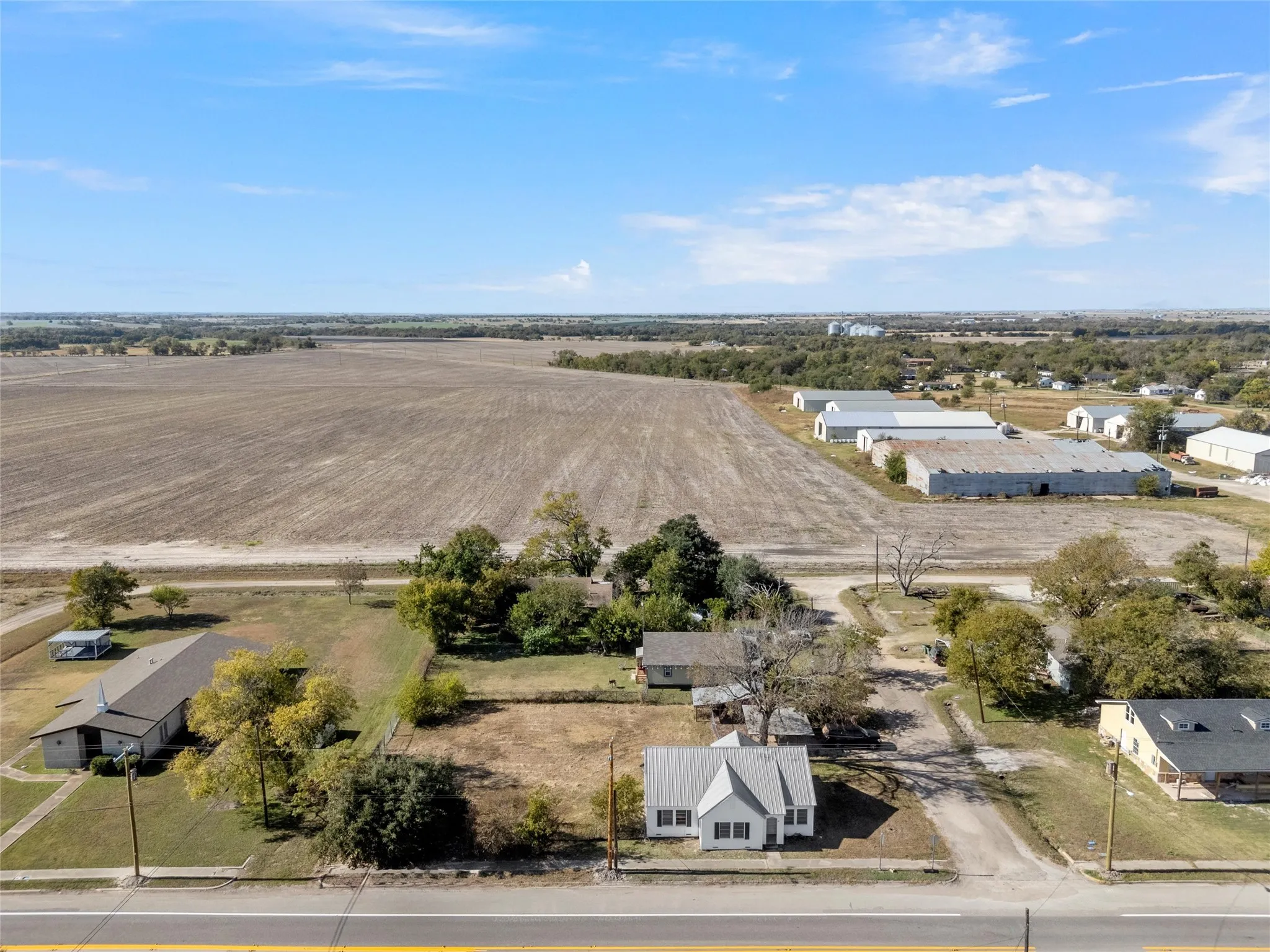 Aerial perspective showcasing a parcel with established trees and surrounding agricultural land