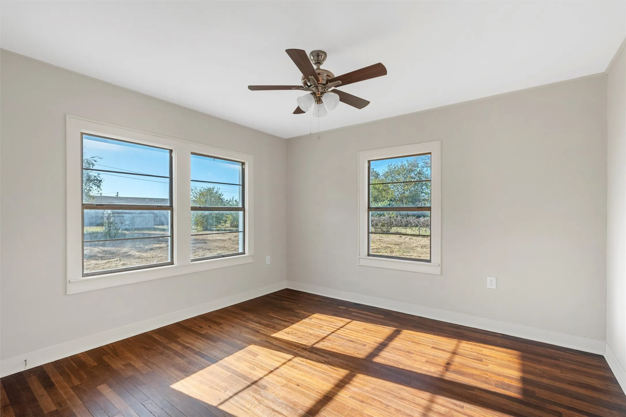 Bright room featuring wood-finish flooring and three windows