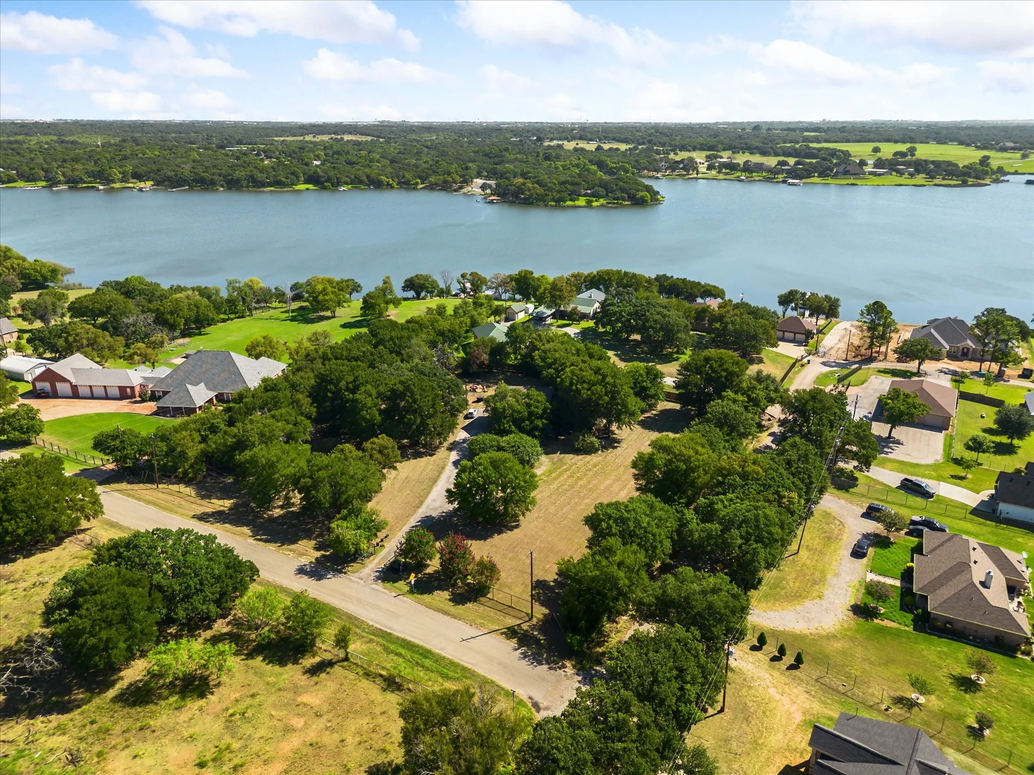 Aerial perspective showcasing a broad expanse of water, surrounding land, and multiple residential properties