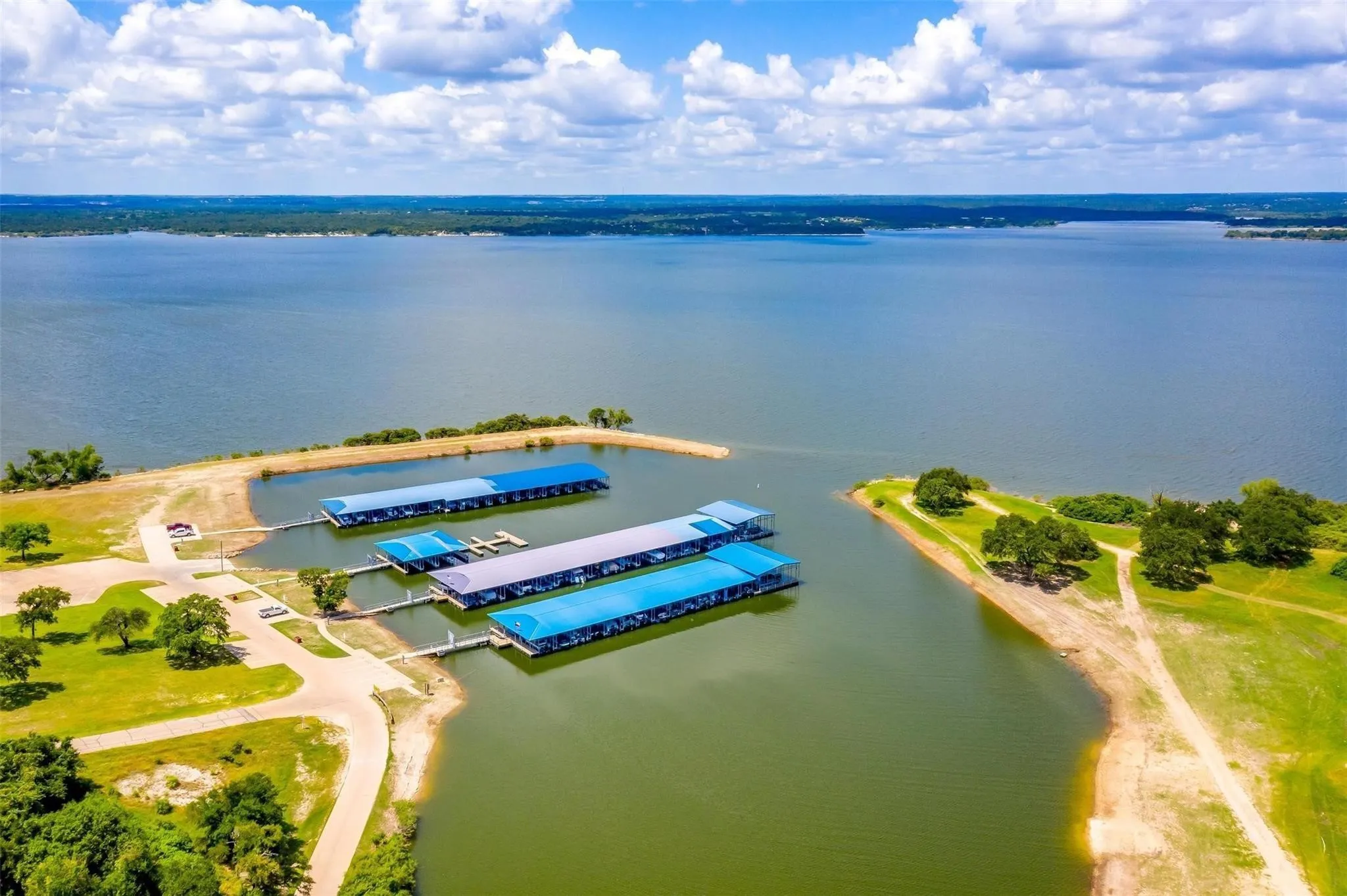 Expansive lakefront property featuring multiple covered boat docks with direct water access
