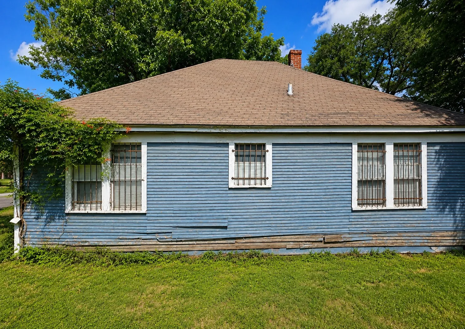 Blue horizontal siding exterior with a brown shingle roof