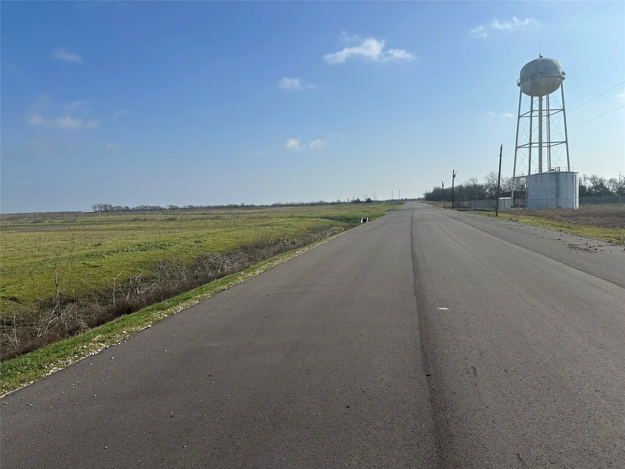 Paved road frontage with expansive, undeveloped land