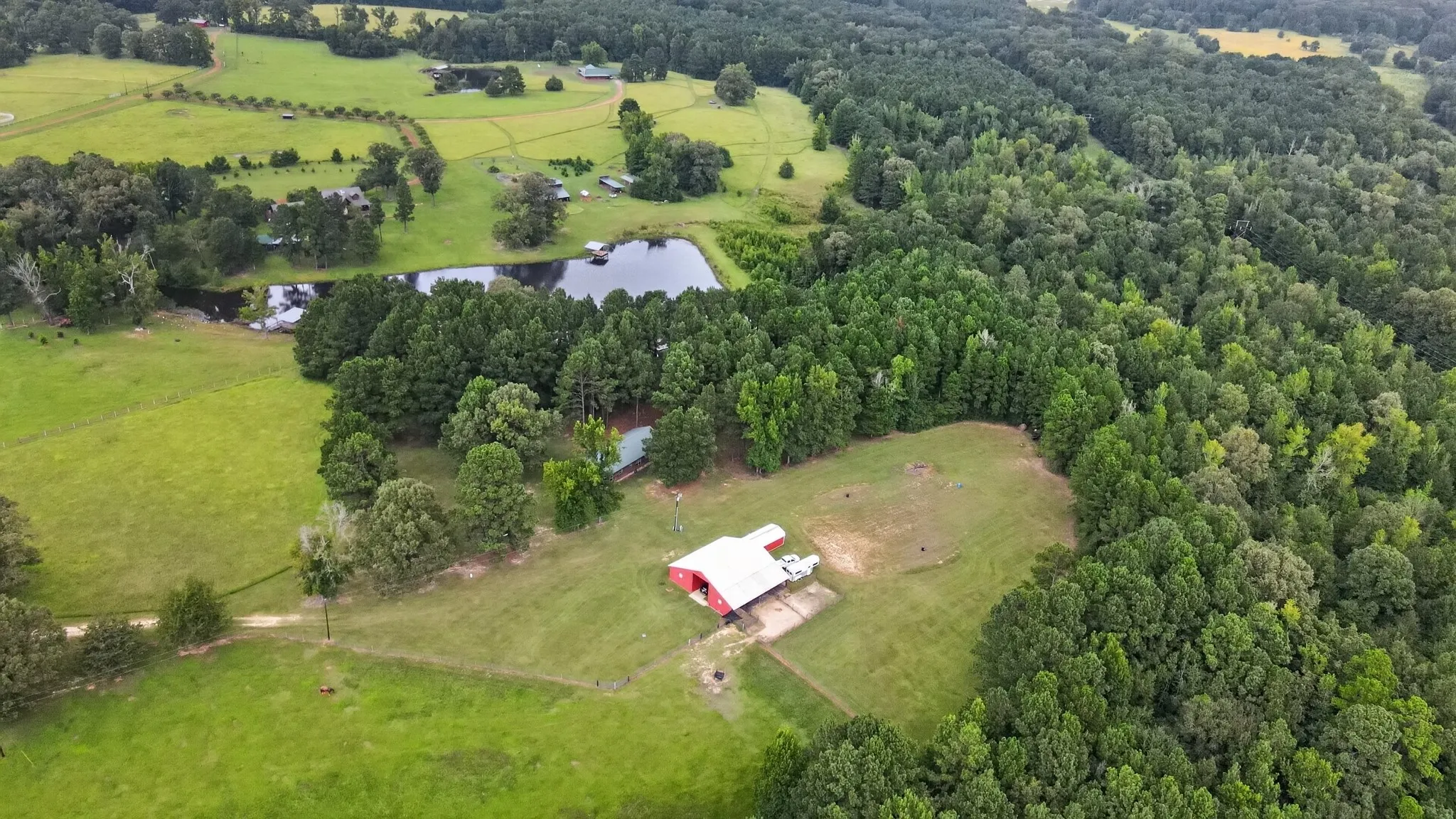 Expansive aerial view of Kellyville Ranch, featuring lush pastures, mature hardwoods, outstanding equestrian community.