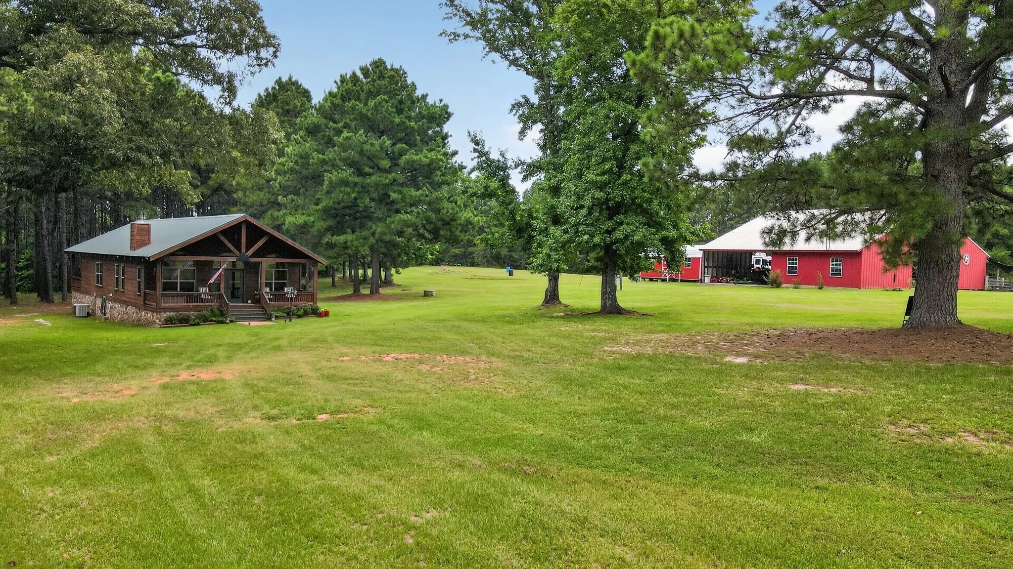Front view showcasing the beautiful home, equestrian barn and spacious workshop/storage building.