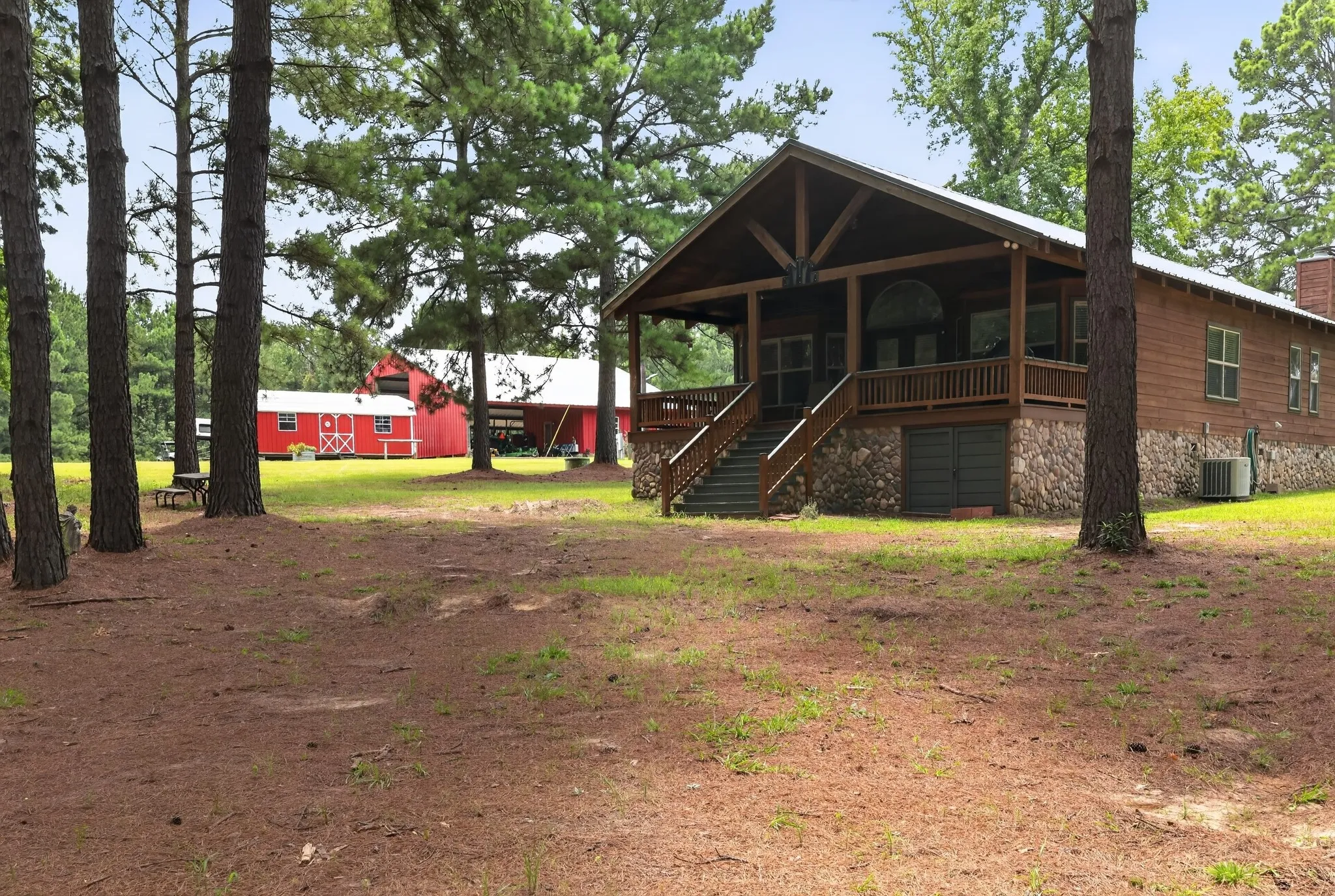 Back view showcasing the beautiful home, equestrian barn and spacious workshop/storage building.