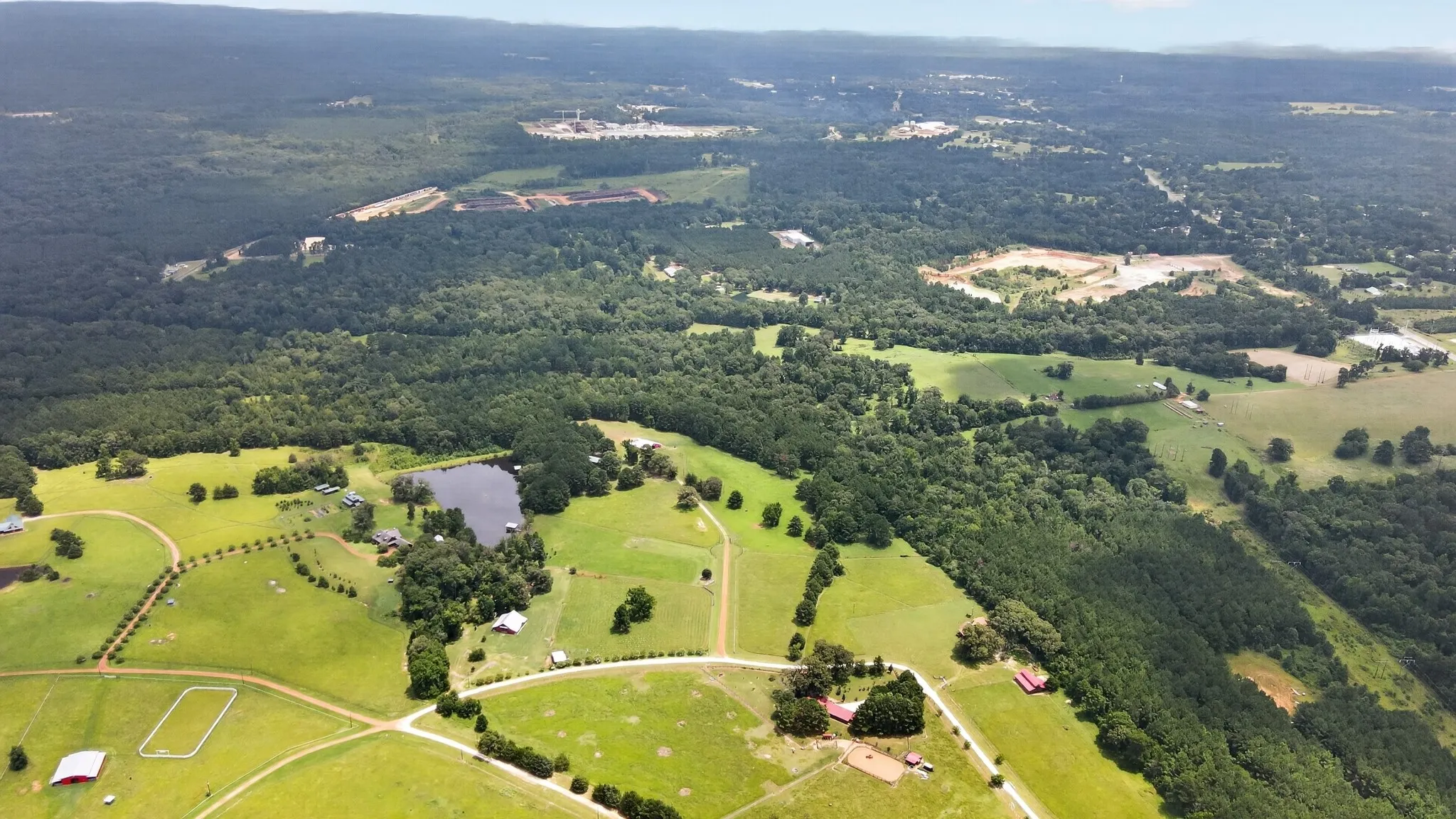 Expansive aerial view of Kellyville Ranch, featuring lush pastures, mature hardwoods, outstanding equestrian community.