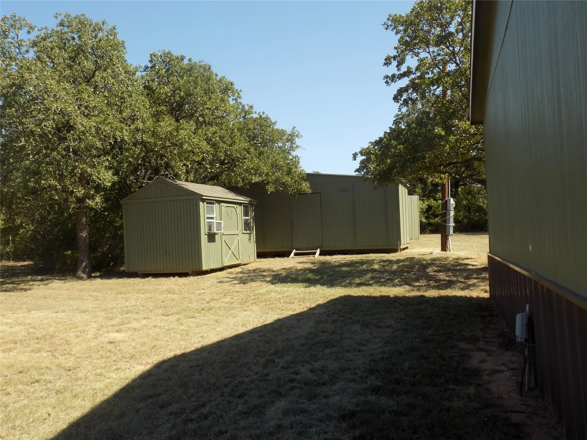 View of outside buildings, one, 8'x12', the second, 12'x24'; perfect for hobbies, storage, or various usages. Both buildings have lights and electricity.