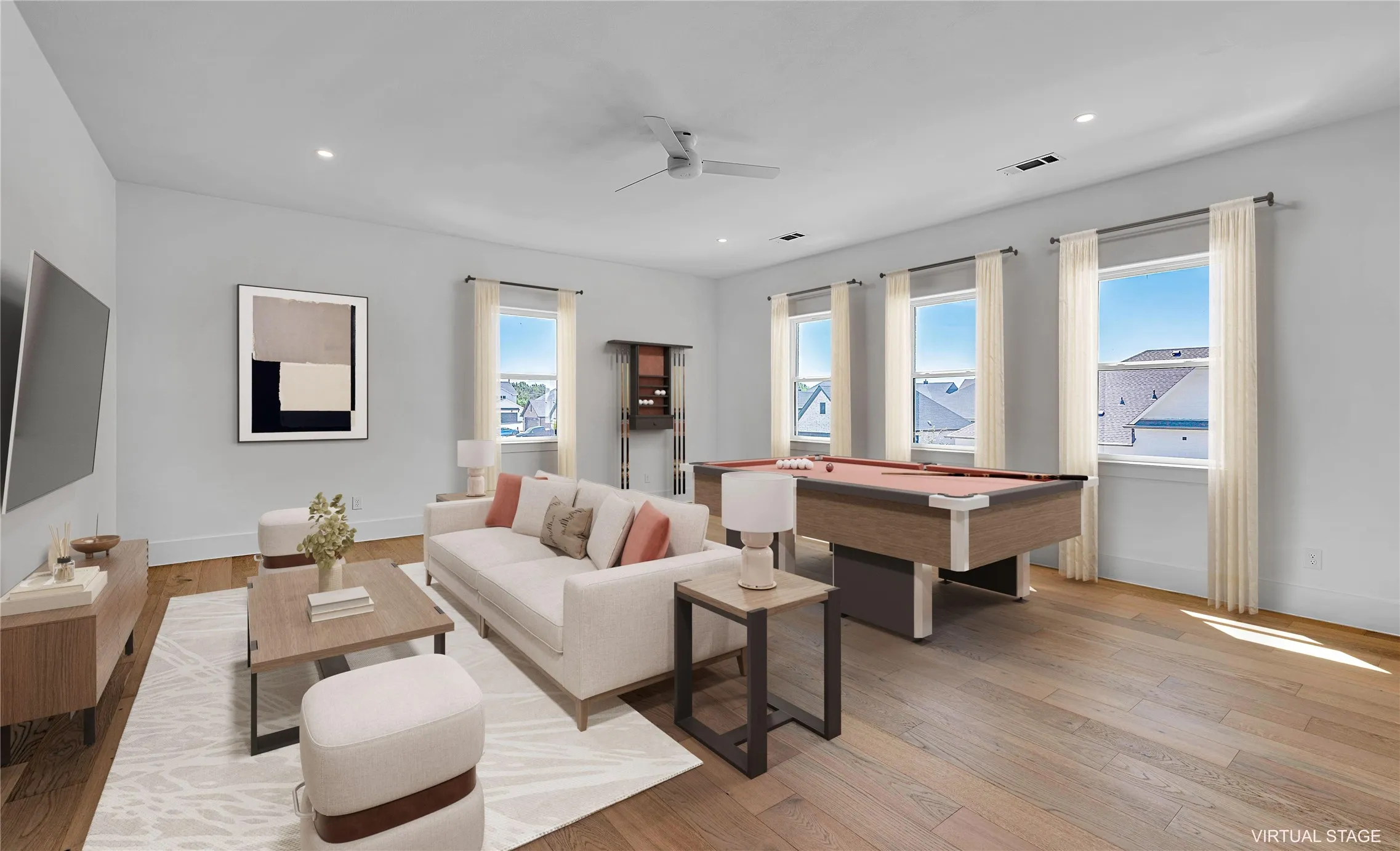 Spacious room featuring wood-finish flooring, recessed lighting, and multiple windows