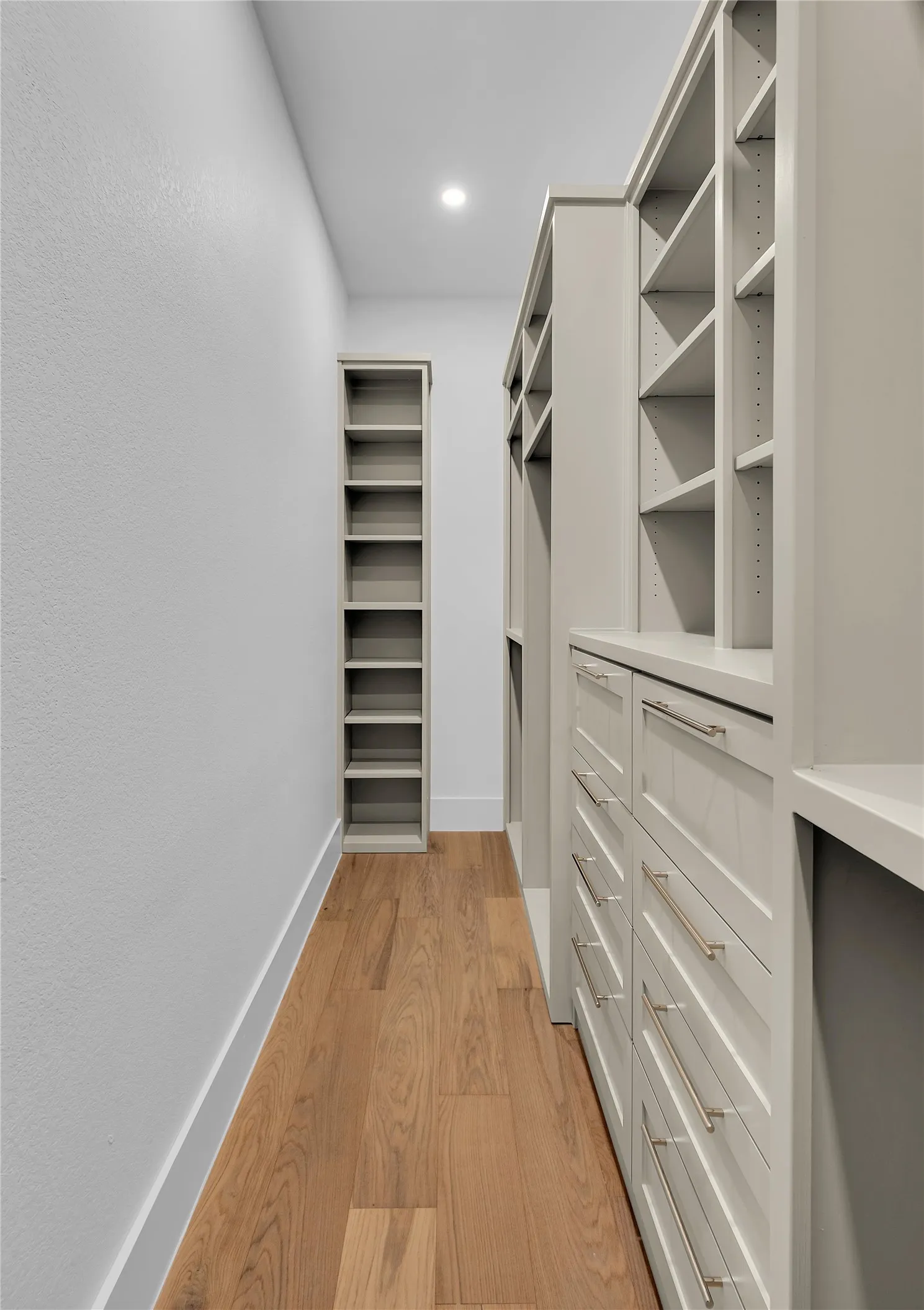 Custom built-in cabinetry and shelving featuring a light gray finish