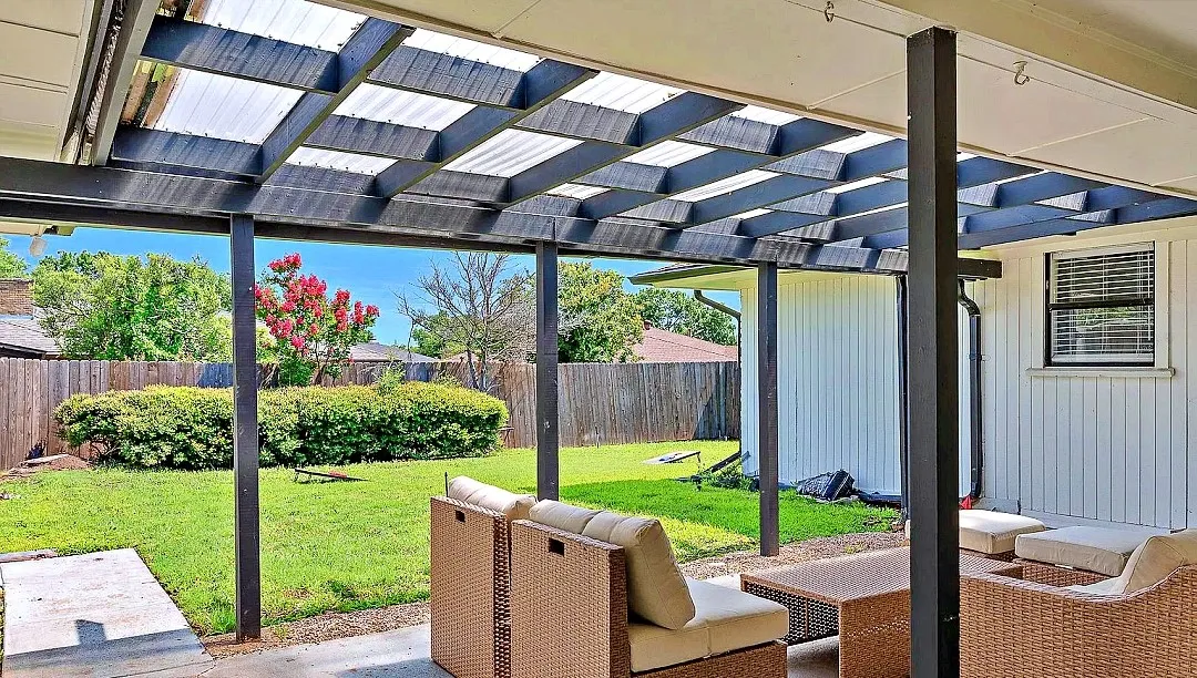 Covered patio featuring a translucent panel roof and dark support beams