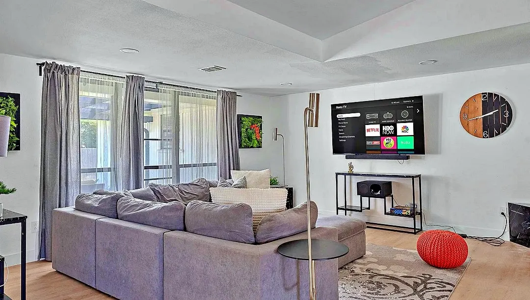Spacious living area featuring wood-finish flooring, recessed lighting, and a tray ceiling