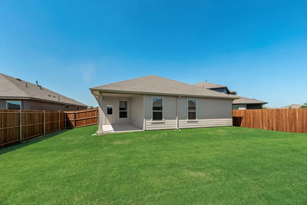 Expansive green lawn with a newly installed wood privacy fence