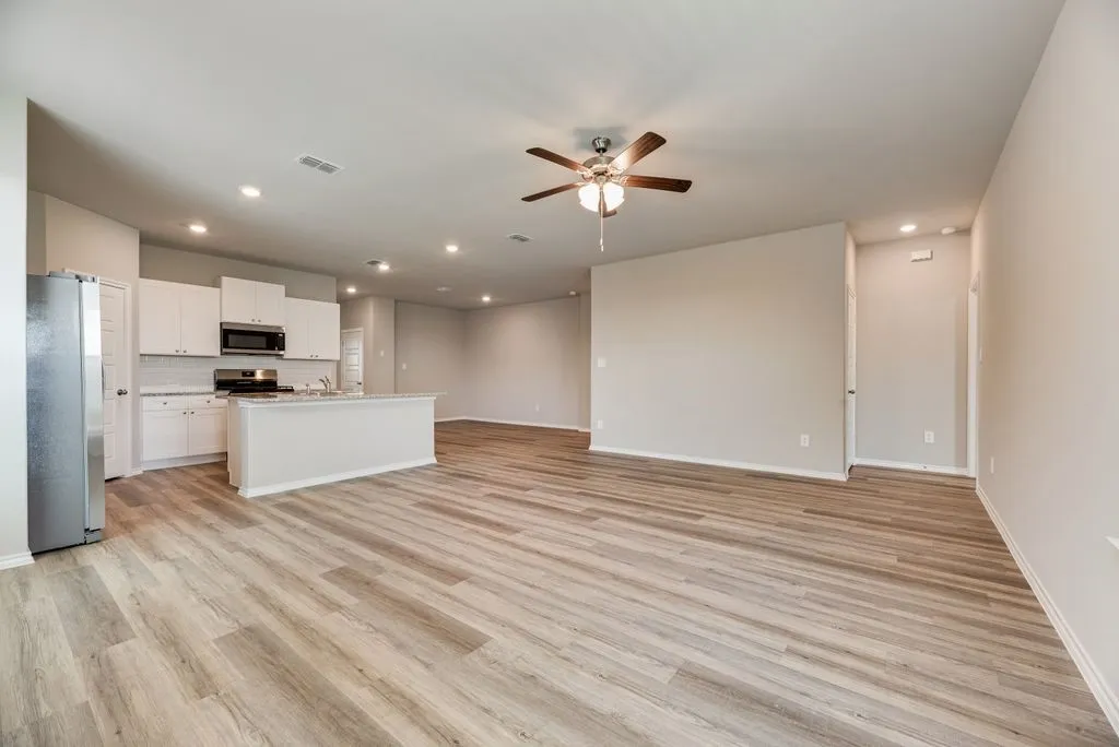 Open-concept living space featuring wood-finish flooring, recessed lighting, and a ceiling fan