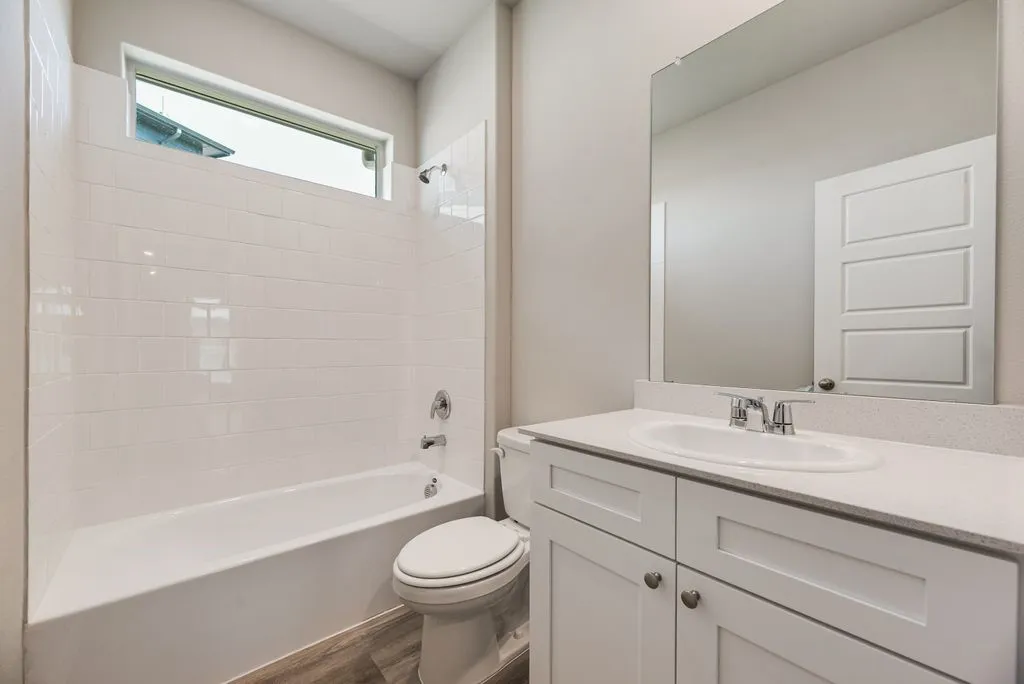 Bathroom featuring a vanity with white cabinetry and a white countertop, an integrated sink, and a chrome faucet