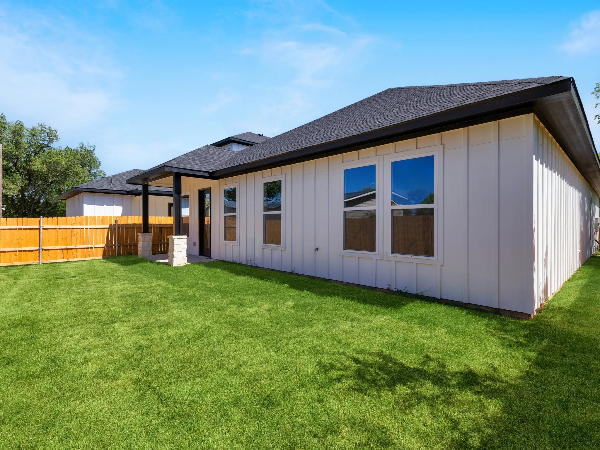 Expansive green lawn bordering the rear exterior of the home