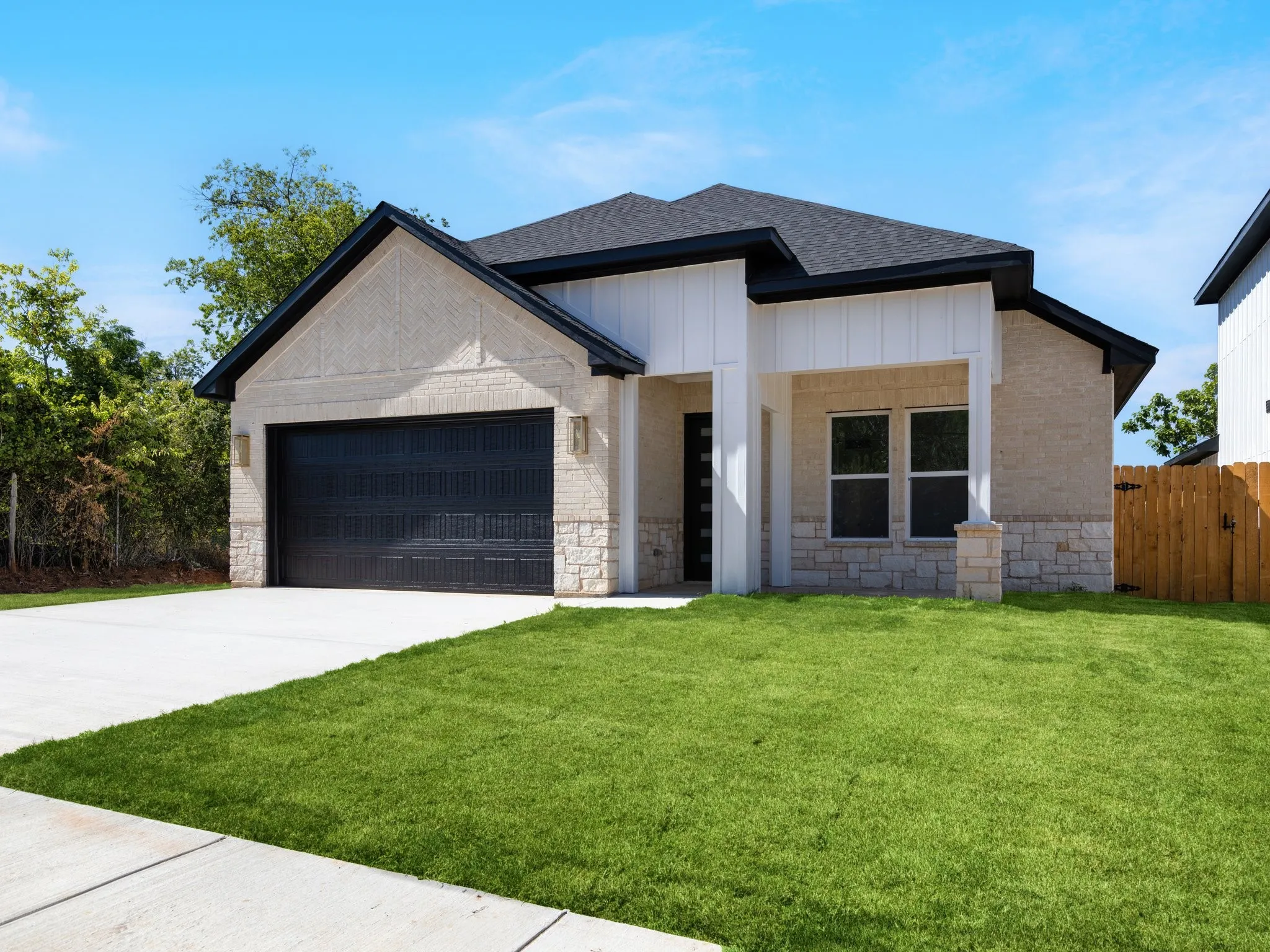 Modern farmhouse exterior featuring light brick and stone accents