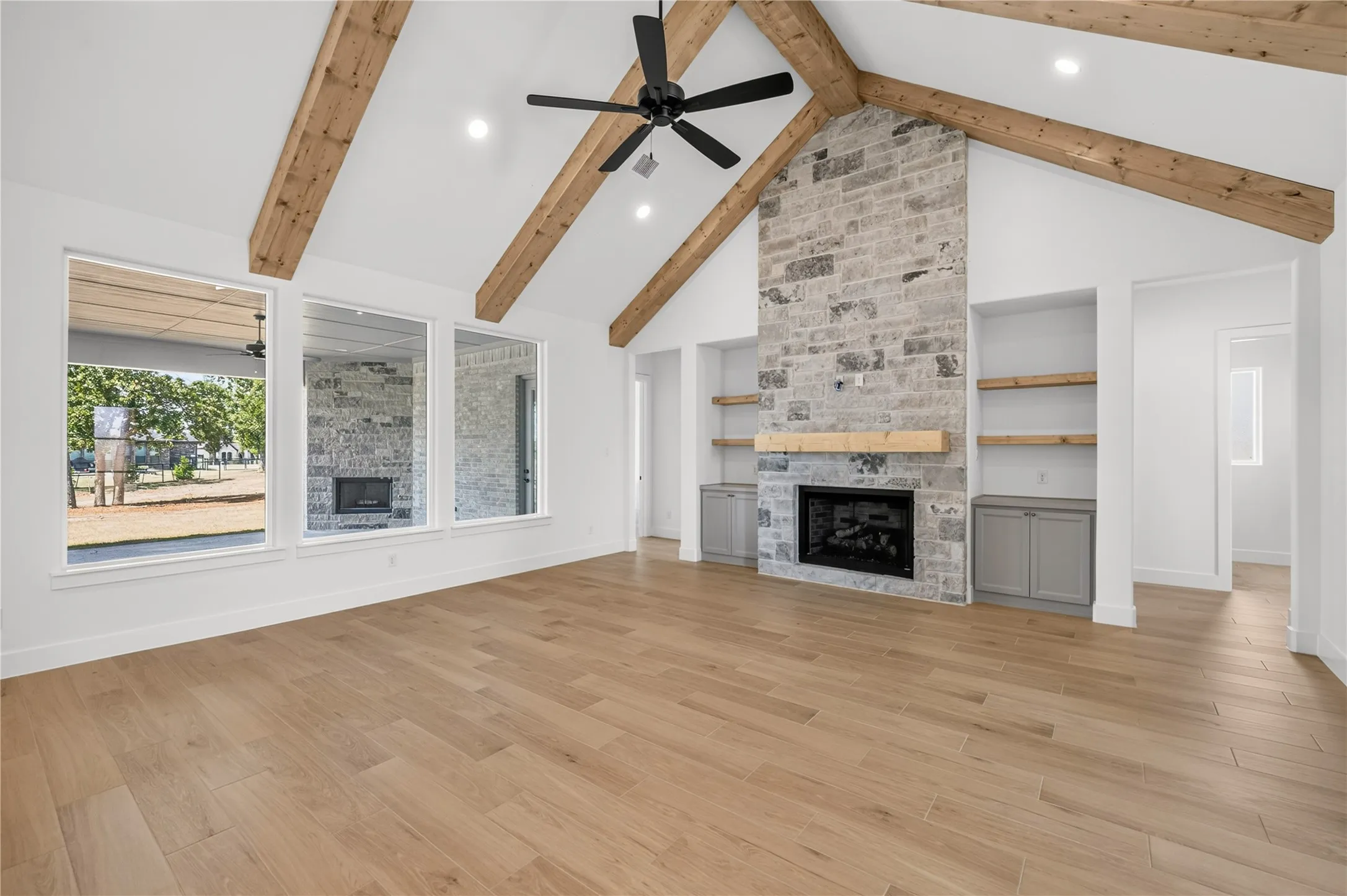 Vaulted ceiling with exposed wood beams and a contemporary ceiling fan