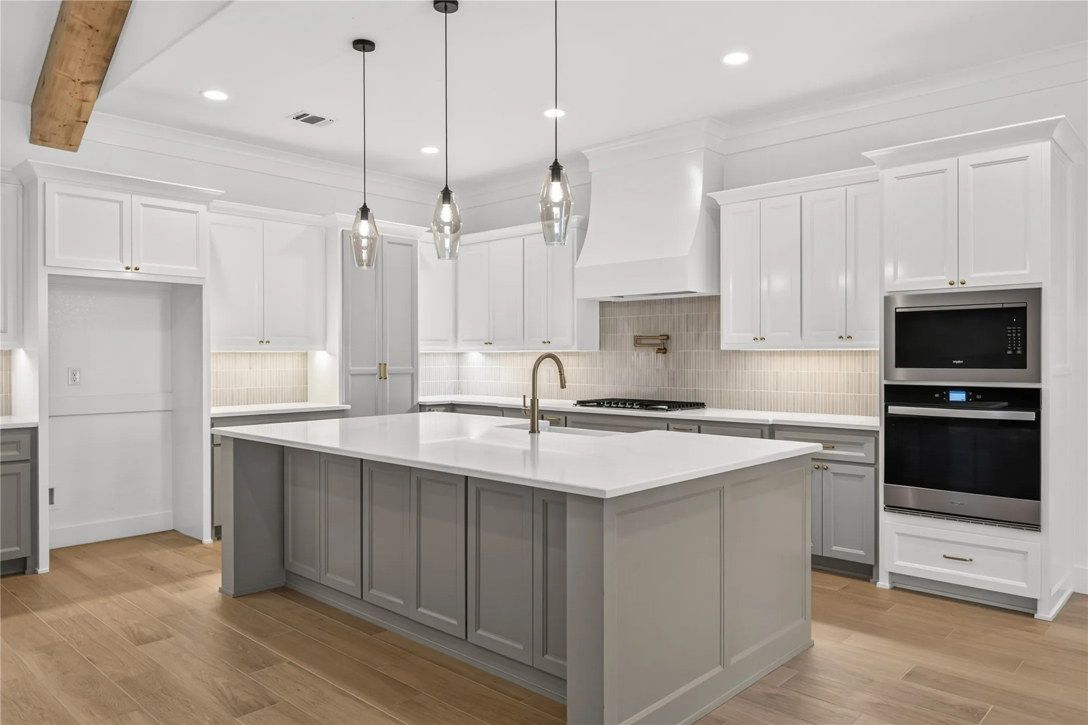 Kitchen featuring a central island with integrated storage, white countertops, and a gooseneck faucet