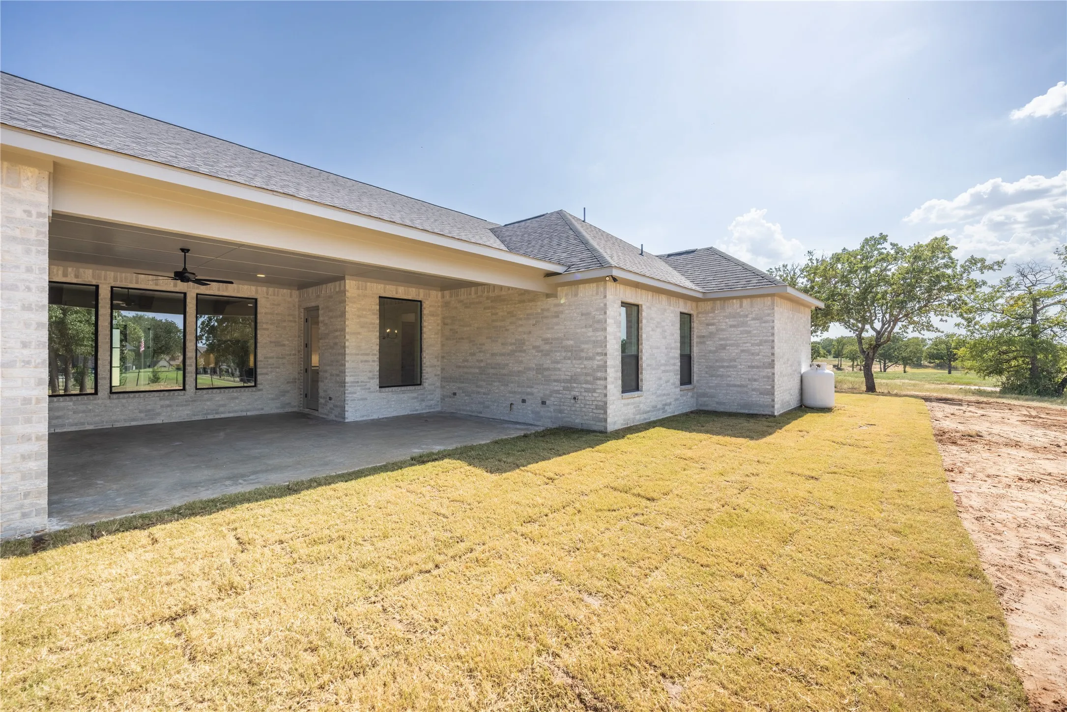 Expansive covered patio featuring a ceiling fan and concrete flooring