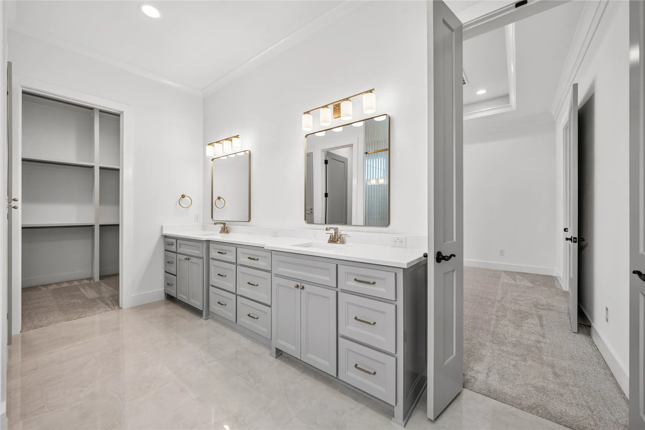 Bathroom featuring a dual vanity with light gray cabinetry, white countertops, and bronze hardware