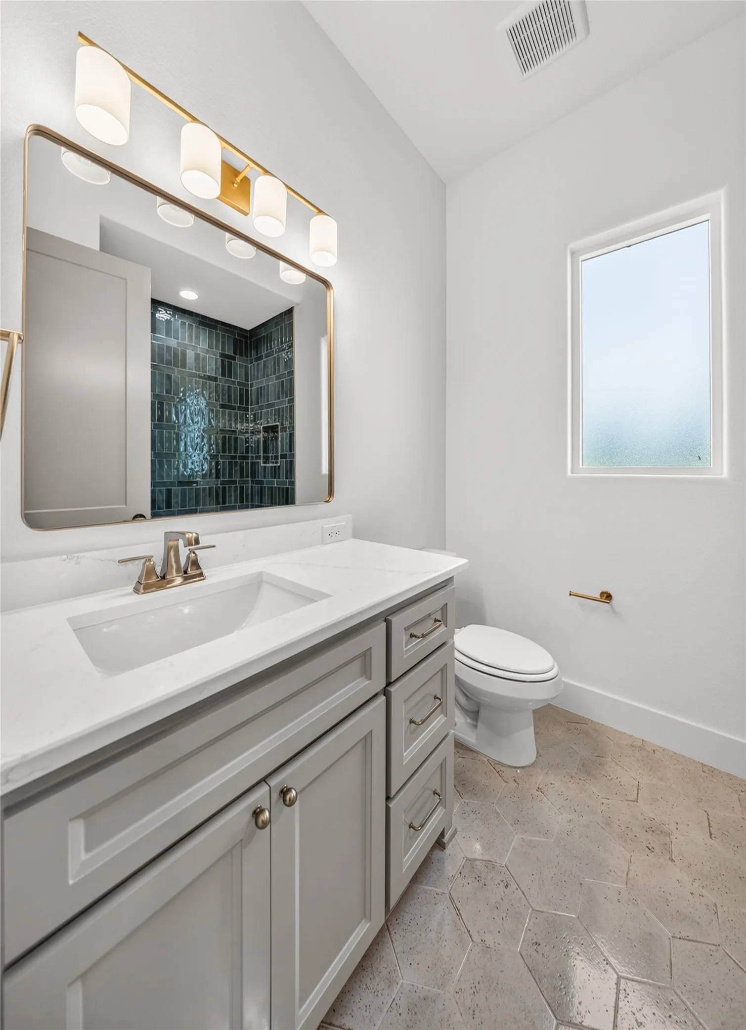 Bathroom featuring a single vanity with gray cabinetry, a white countertop, and an integrated sink