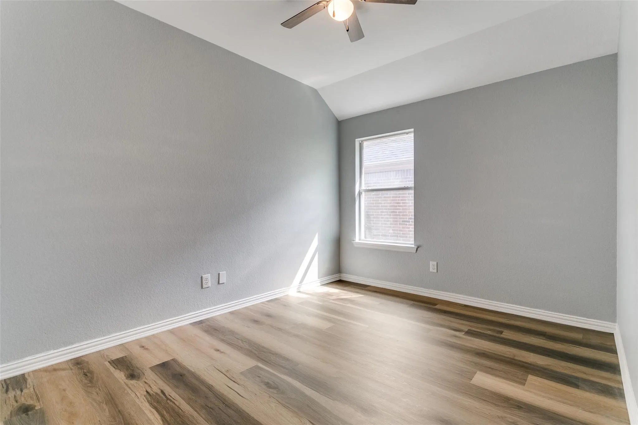 Interior space featuring wood-finish flooring, light grey walls, and white baseboards