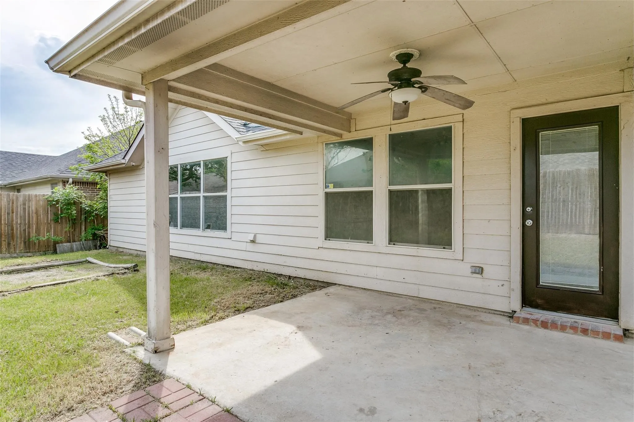 Covered patio featuring a ceiling fan, concrete flooring, and direct exterior access