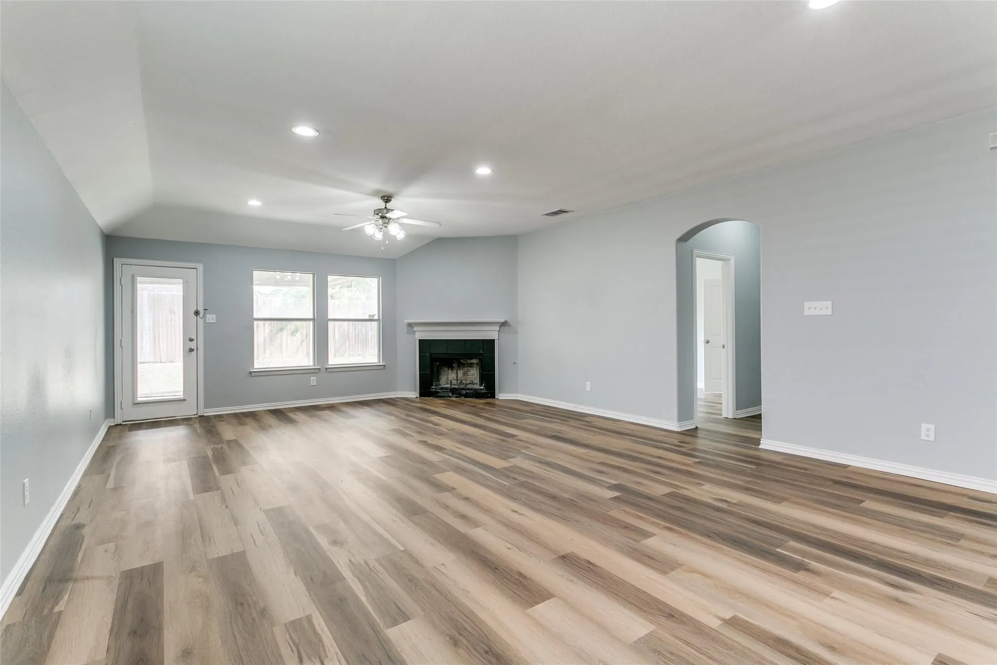 Spacious interior featuring wood-finish flooring, a recessed lighting package, and a ceiling fan