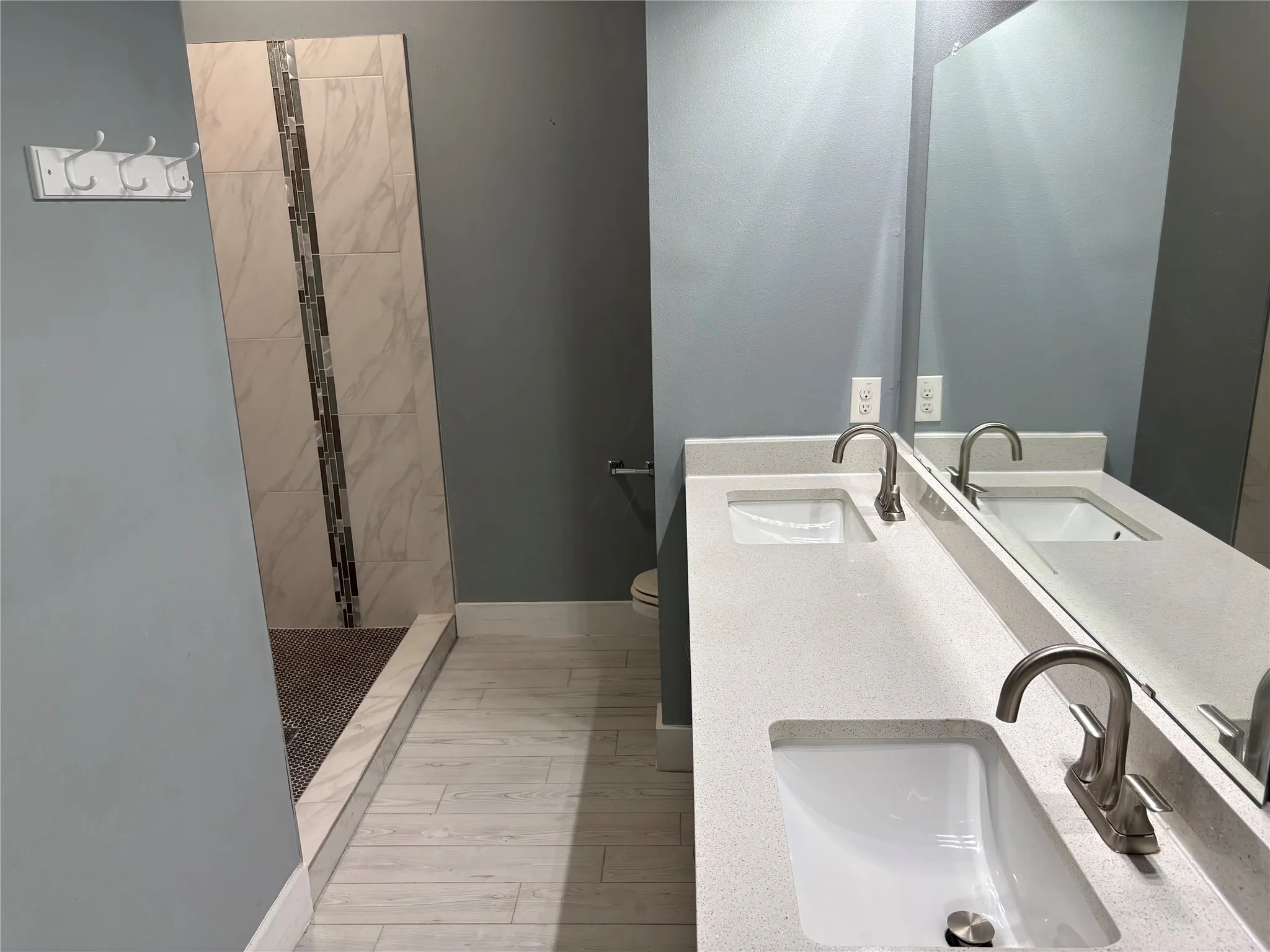 Bathroom featuring a double vanity with integrated sinks and a large wall-mounted mirror