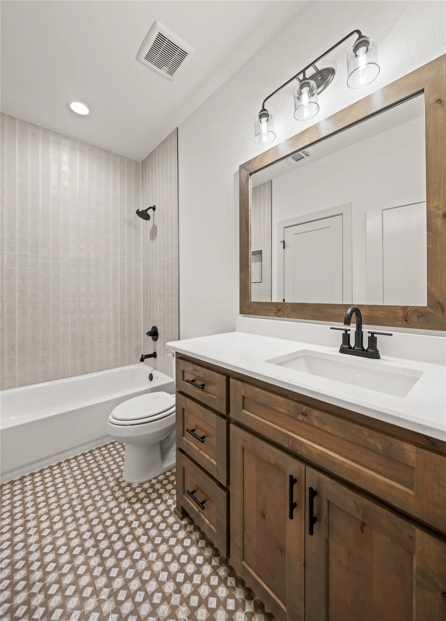 Bathroom vanity featuring wood-finish cabinetry, a white countertop, and a rectangular undermount sink