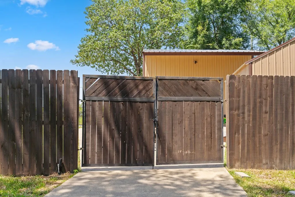 A view of the double gates and concrete drive up to the outbuildings.