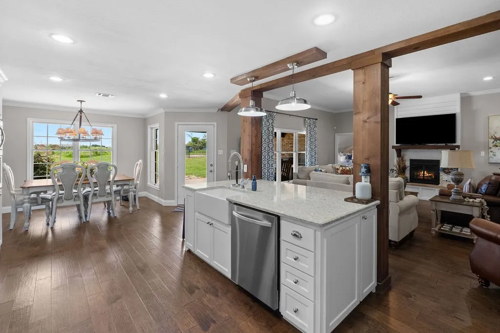 View of island surrounded by cedar beams, breakfast bar and dining area