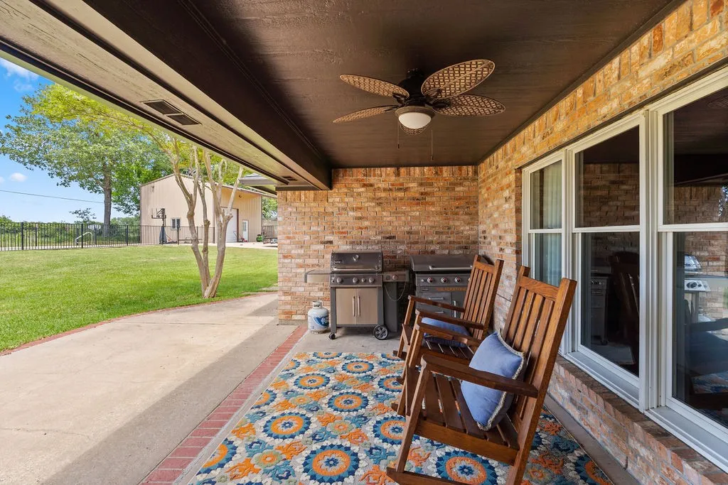 Peaceful shaded back porch with poured concrete patio; sit under the fan with a view of your pool and the pasture beyond.
