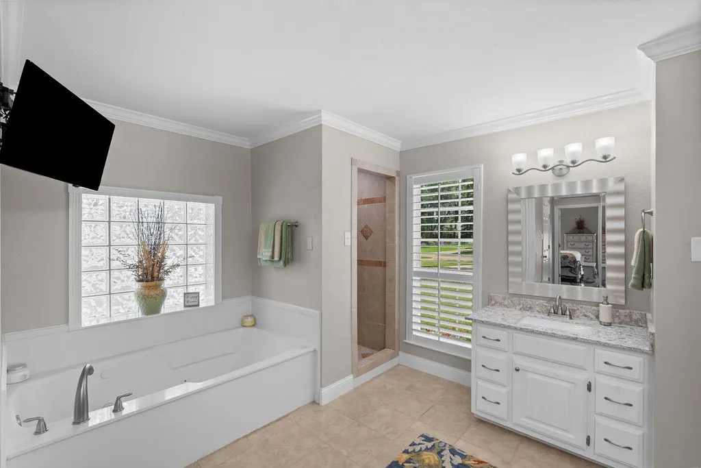 Primary bath is a spa-like retreat, with his and hers vanities, jetted tub, private potty closet, and fully-tiled separate shower.