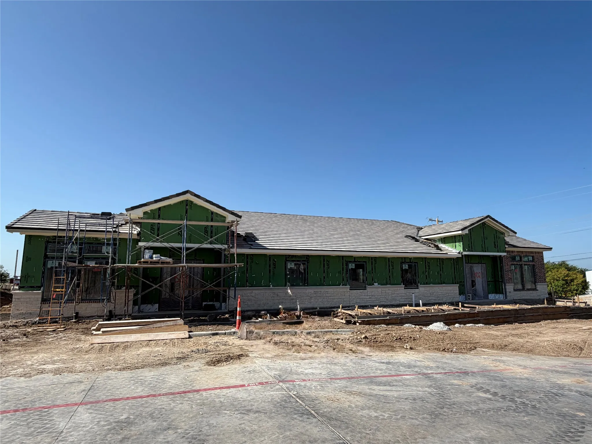 New construction featuring a shingle roof and brick exterior accents