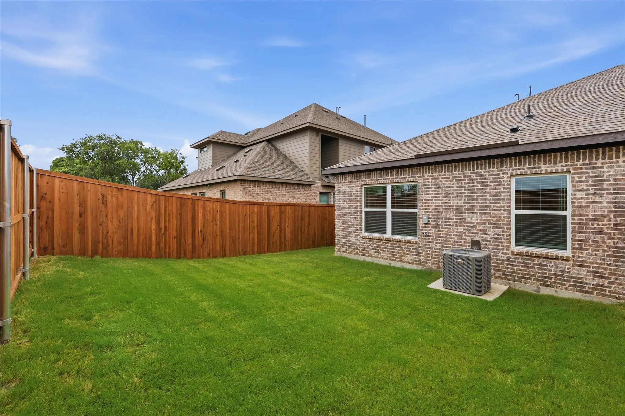 Expansive green lawn featuring a solid wood privacy fence
