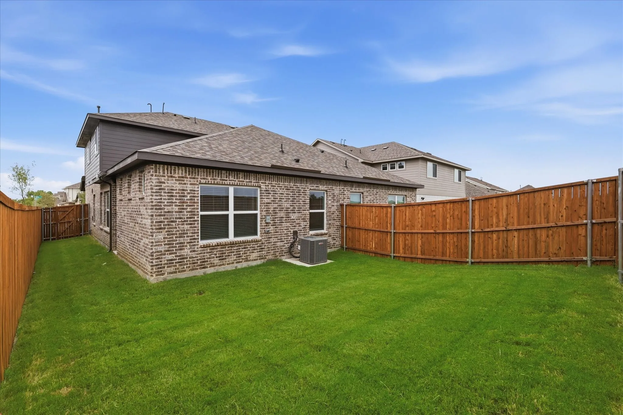 Expansive green lawn surrounded by a privacy fence