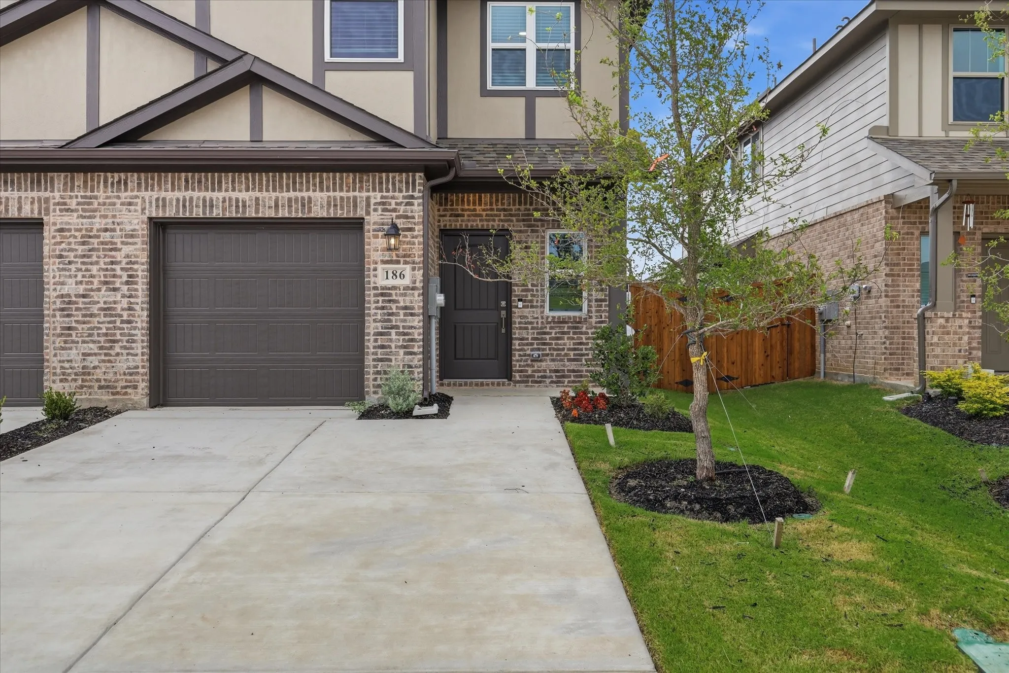 Brick and siding exterior with a dark brown garage door and front door