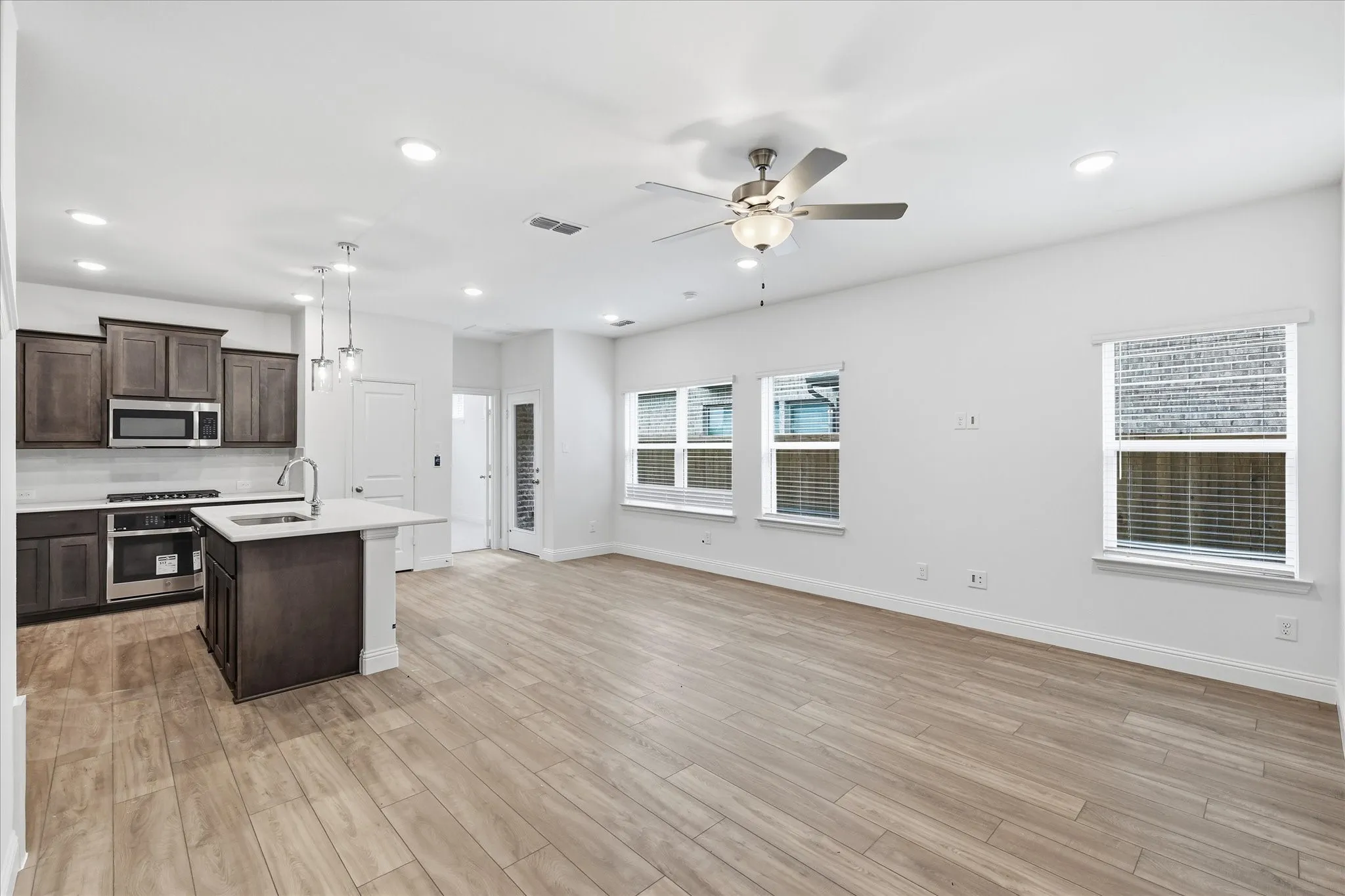 Open-concept living area featuring wood-finish flooring and ample natural light