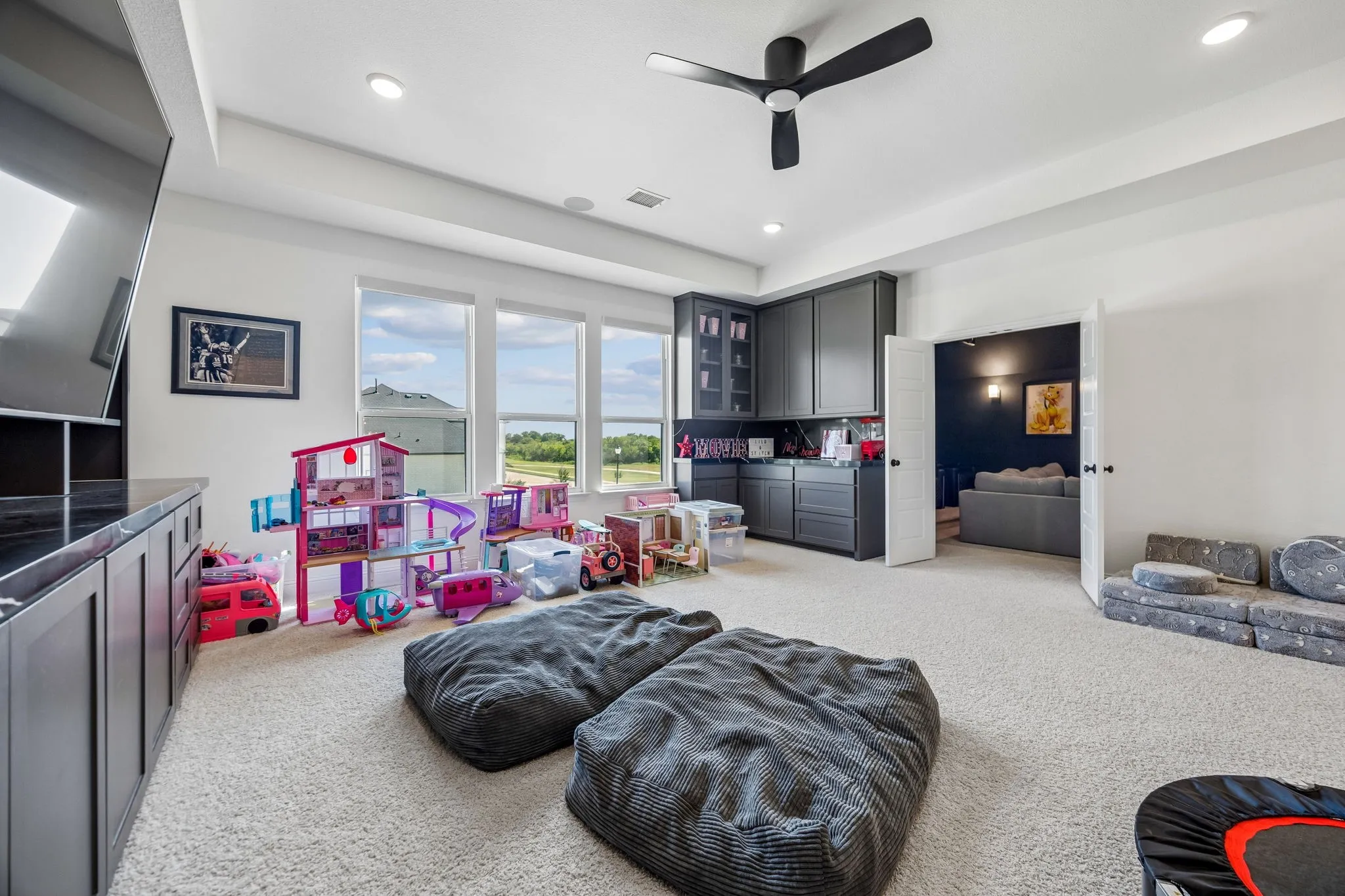 Spacious bonus room featuring plush carpet, a ceiling fan, recessed lighting, and a large window array.