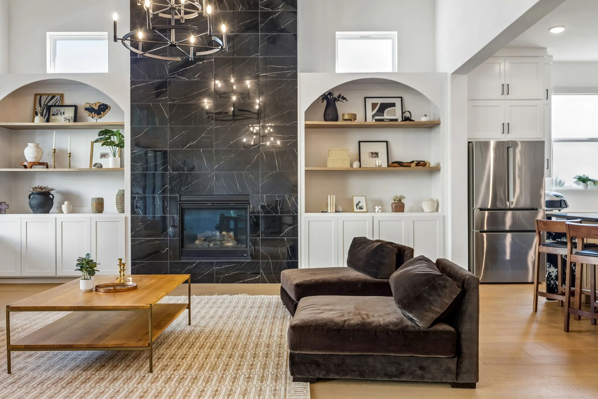Bright bedroom featuring a large window, textured accent wall, plush carpet, and a flush-mount ceiling light fixture