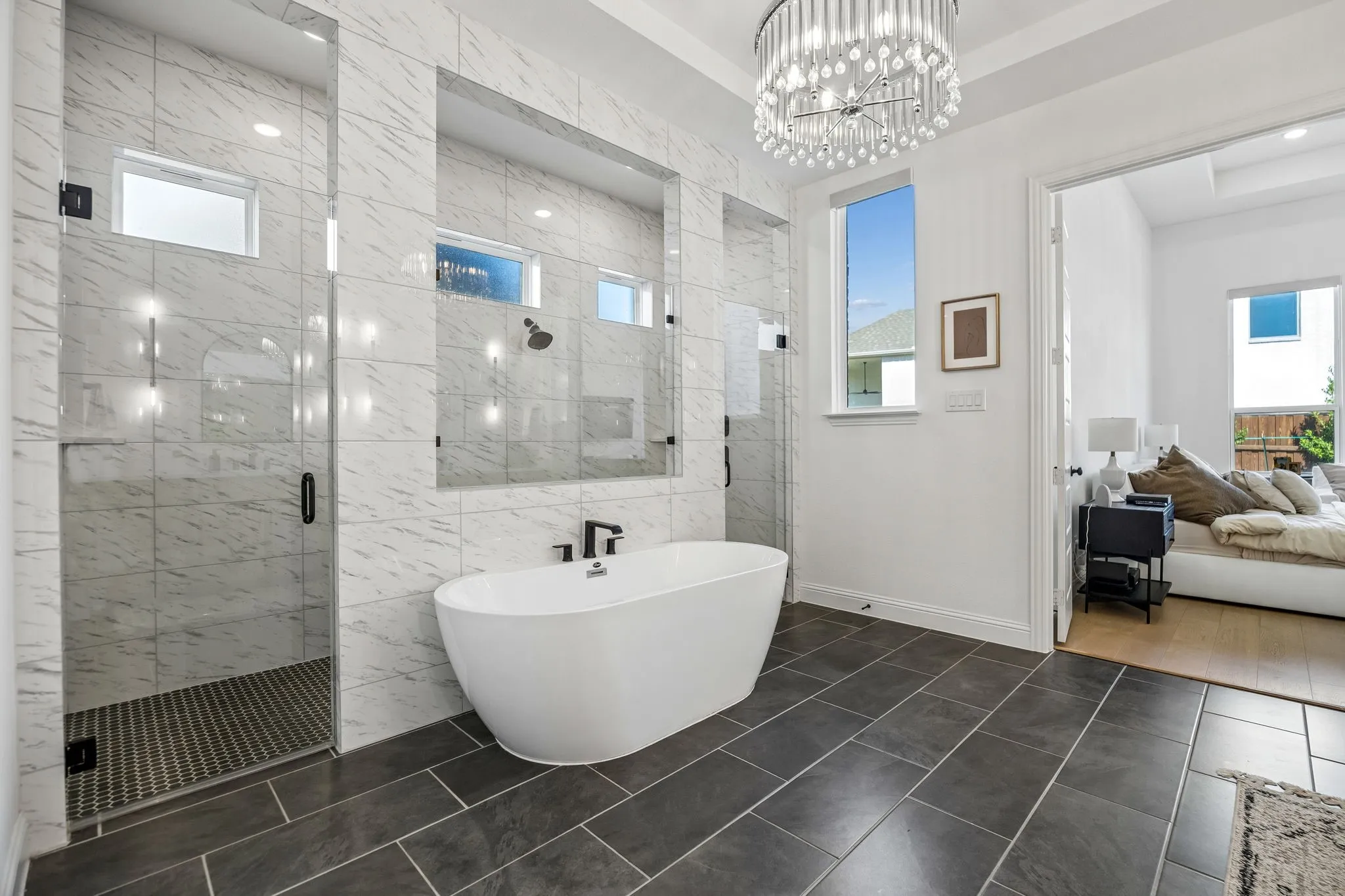 Spacious room featuring vaulted ceilings, a contemporary chandelier, and wood-finish flooring