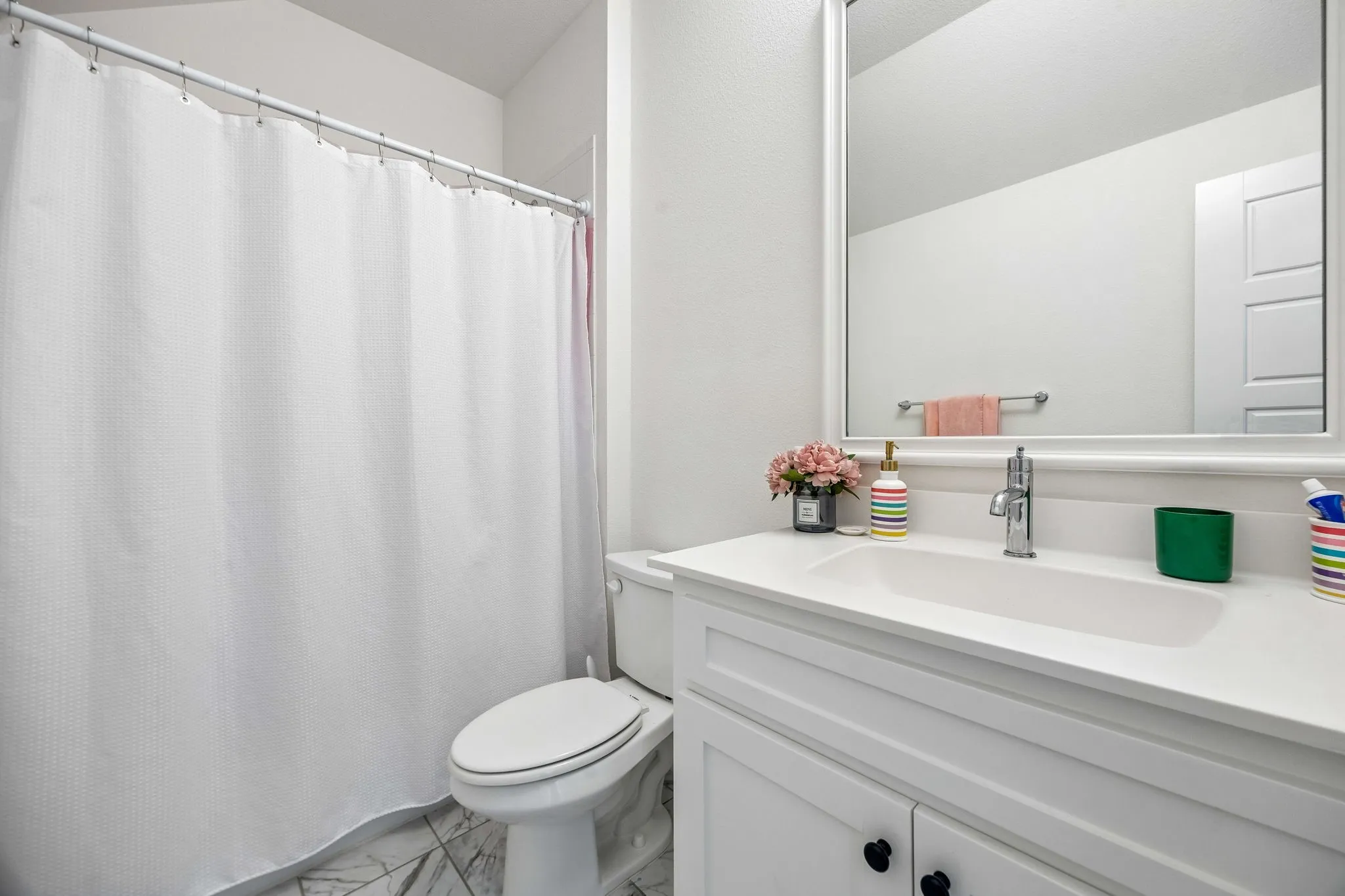 Bathroom featuring a white vanity with an integrated sink, polished chrome faucet, and a wall-mounted mirror. Each bedroom has it's own bathroom