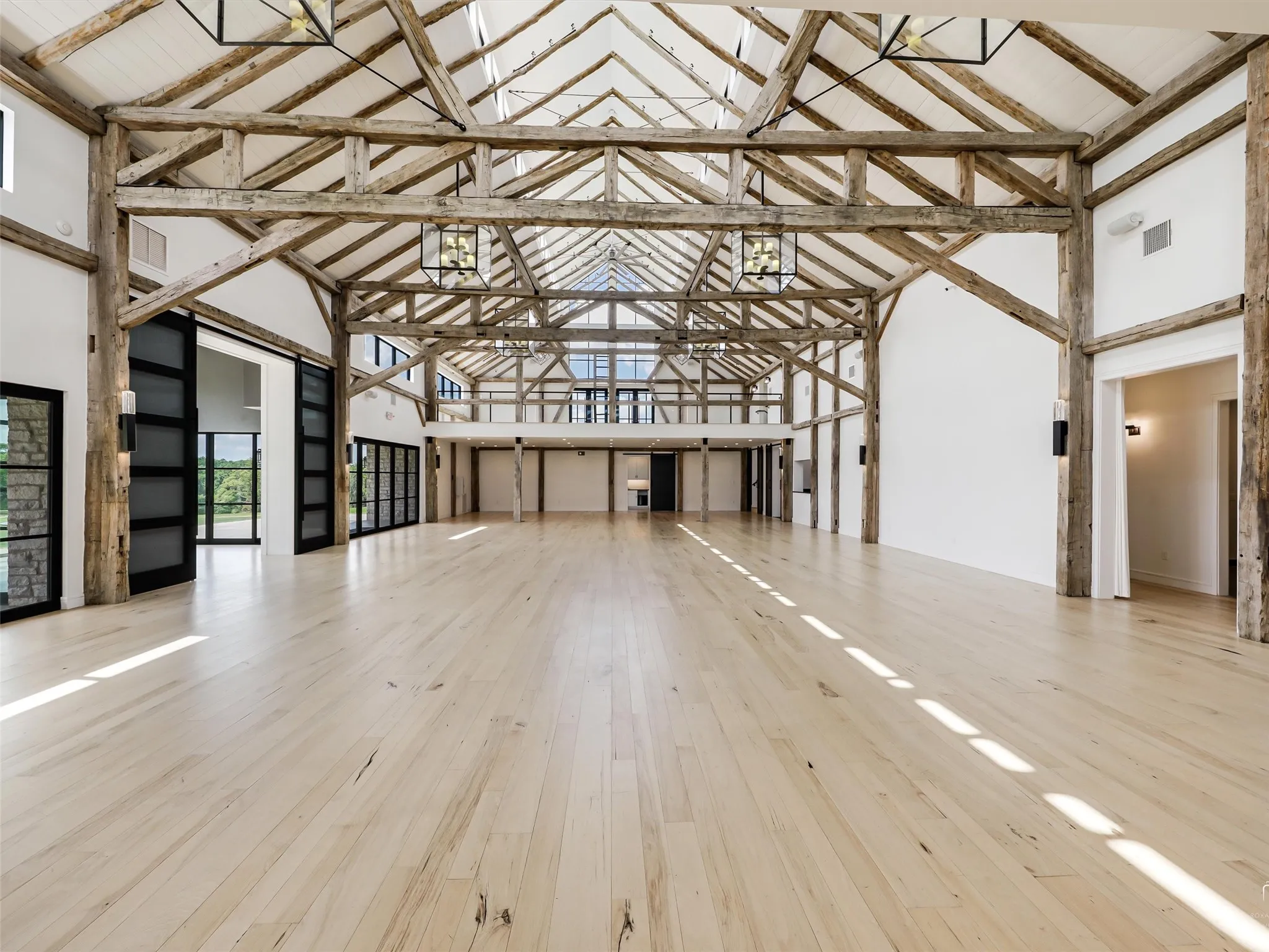 A modern & contemporary structure built
around a hand-hewn oak frame dated from
1853, with 40-foot ceilings at its peak, two
lofts, expansive windows, an outdoor sunset
deck, a beautiful pond, and a large serving
kitchen with a flex space for vendors. The building interior can accommodate 200
seated guests.