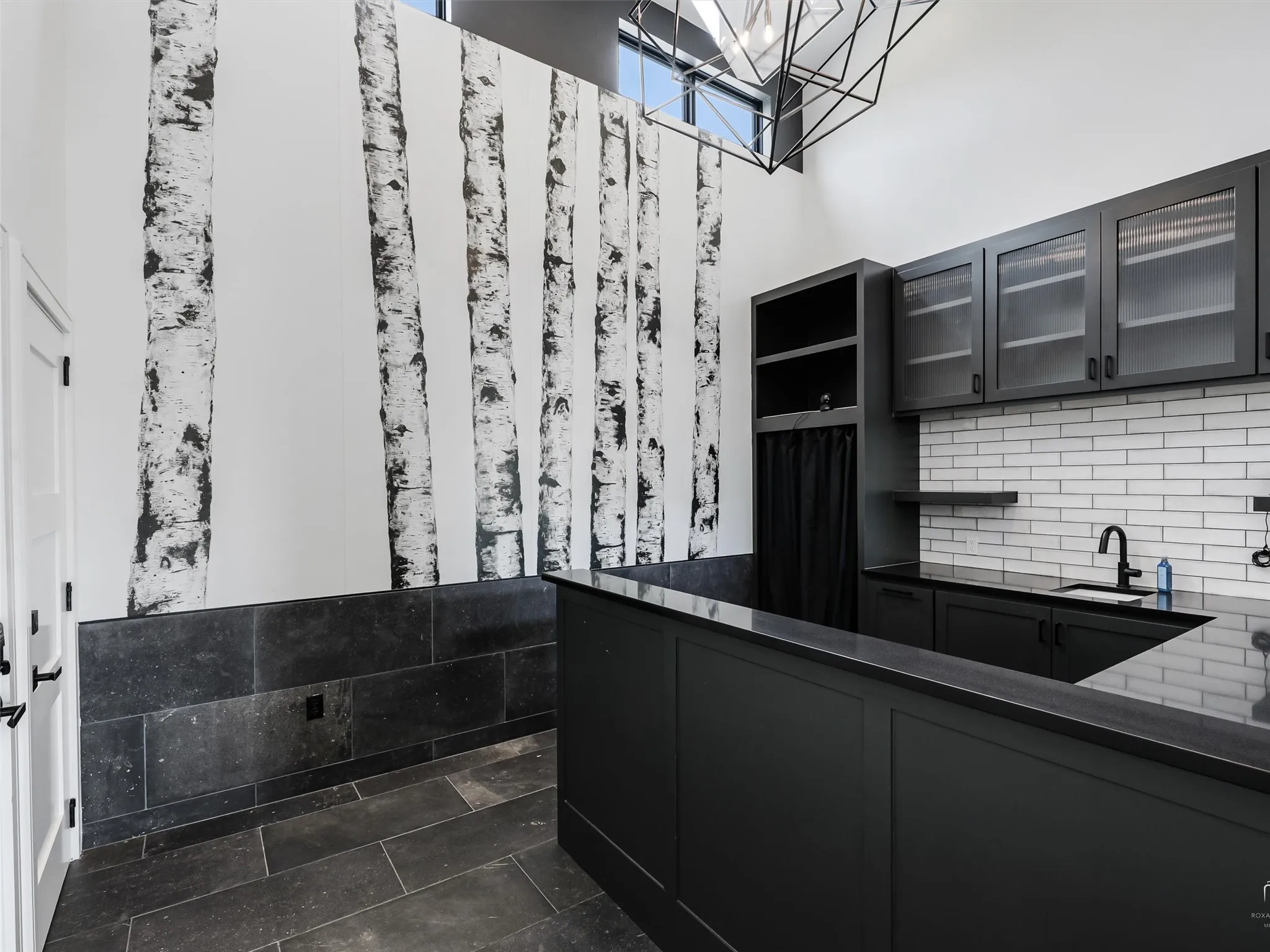 Bar with sink, built-in cabinets, granite countertops and tile flooring.