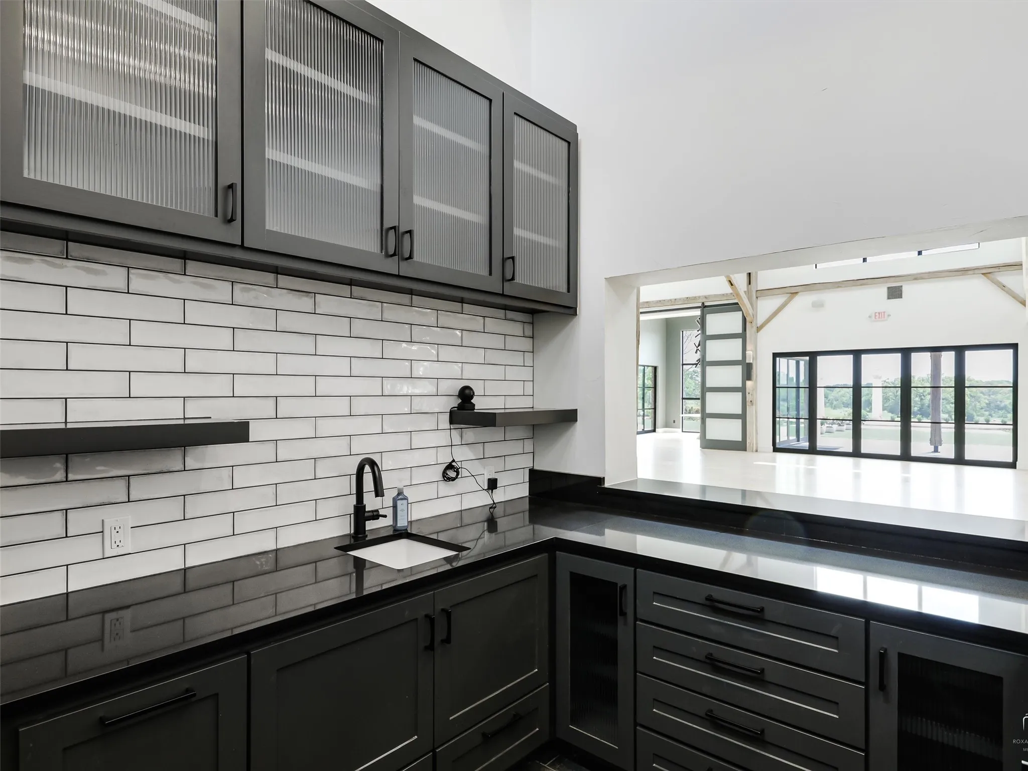 Bar with sink, built-in cabinets, granite countertops and tile flooring.
