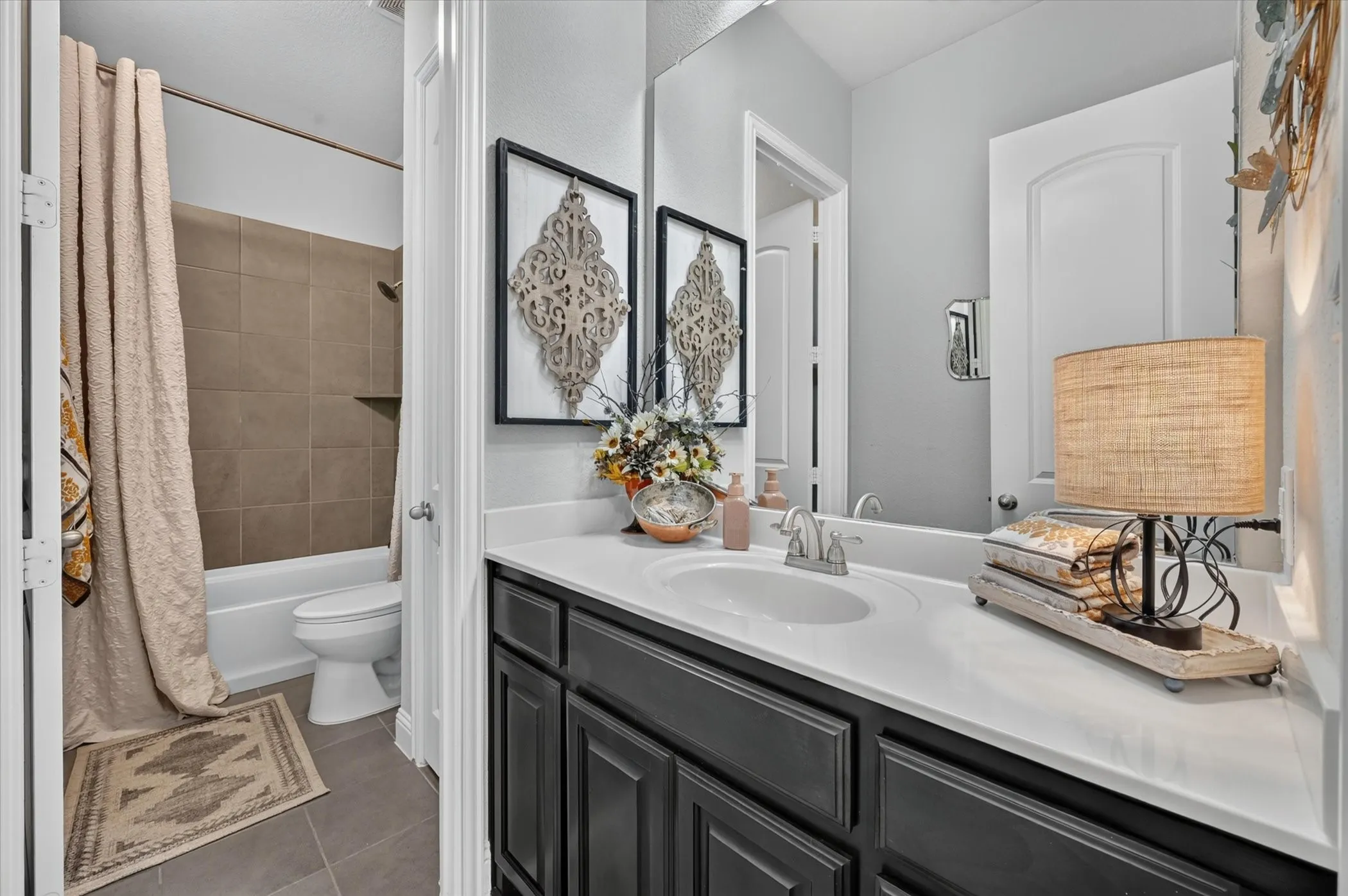 Bathroom featuring a dark wood-finish vanity with a white countertop and an integrated sink