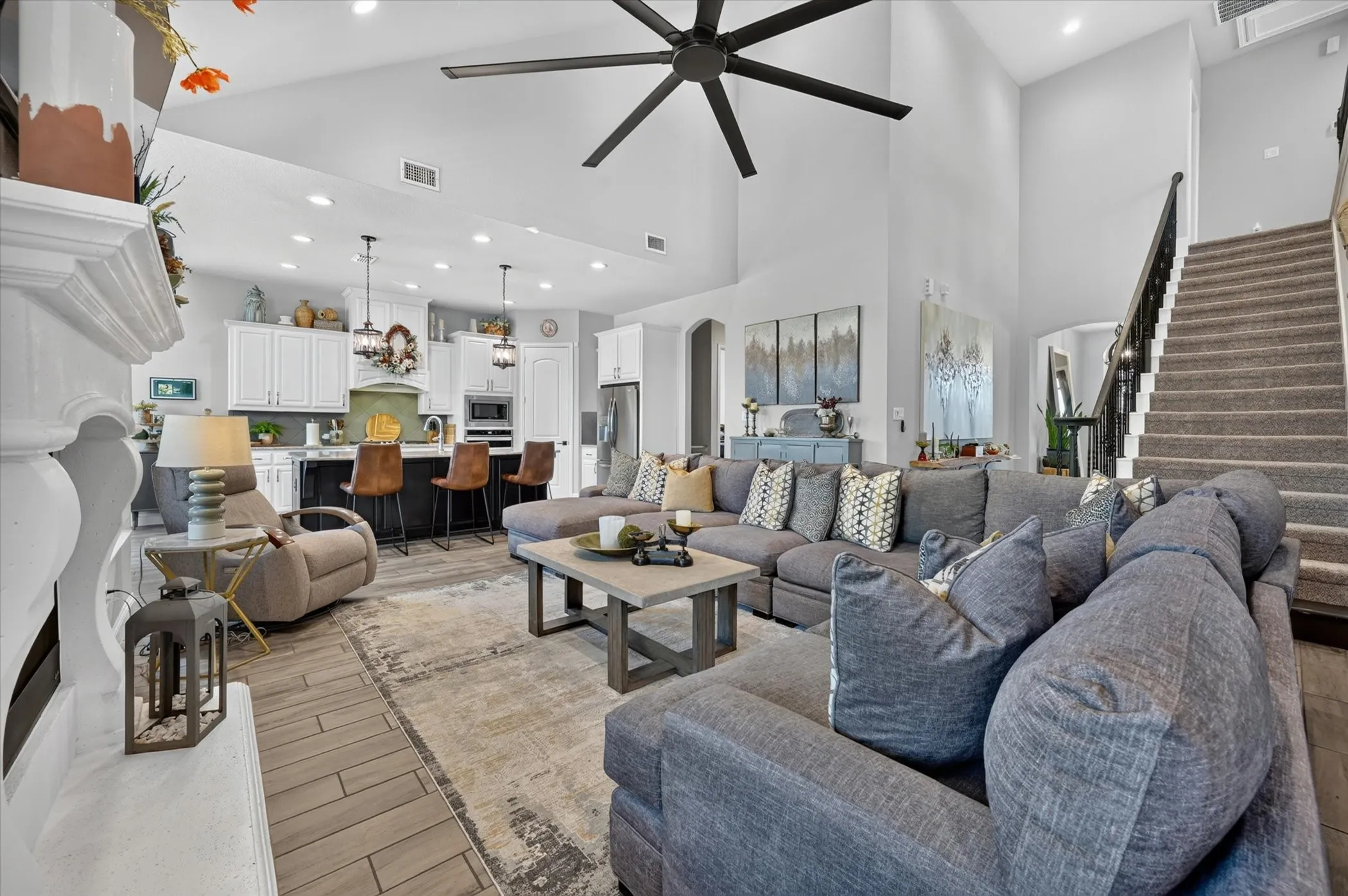 Spacious living area featuring a two-story ceiling, recessed lighting, and a large ceiling fan