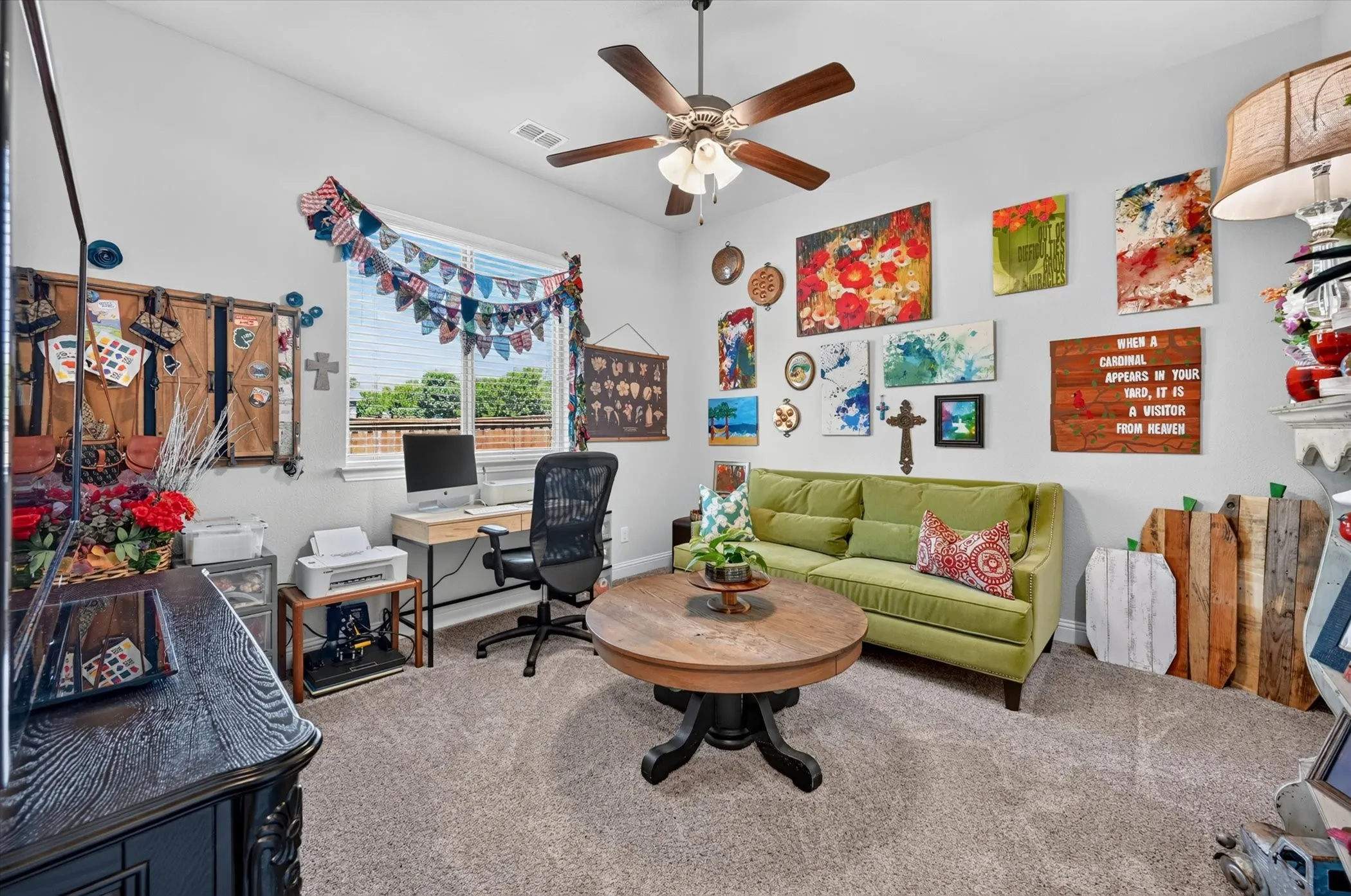 Carpeted room featuring a ceiling fan with integrated lighting, a window with exterior views, and neutral wall tones